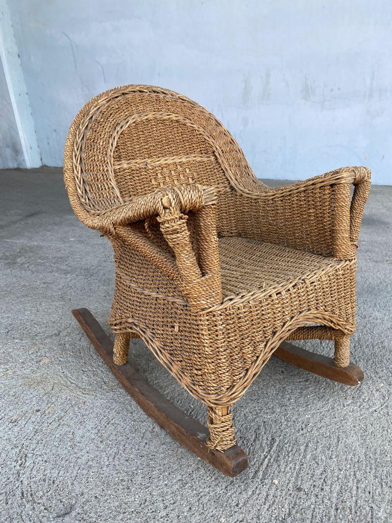 Rare Post-War child-size woven wicker rocking chair with dark stained oak rails along the bottom.

Chair: 26