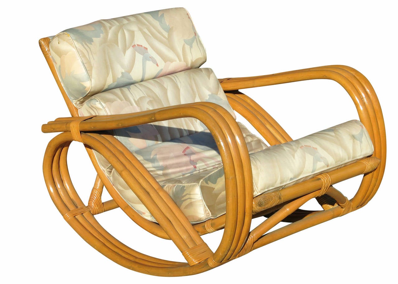 Una rara sedia a dondolo in rattan con braccio a tre fili e pouf abbinato. Questa sedia presenta una struttura in rattan curvato a vapore con cuscini rivestiti di fenicotteri rosa in stile Art Moderne, circa 1984. 

Nota di Harveys: questa rara