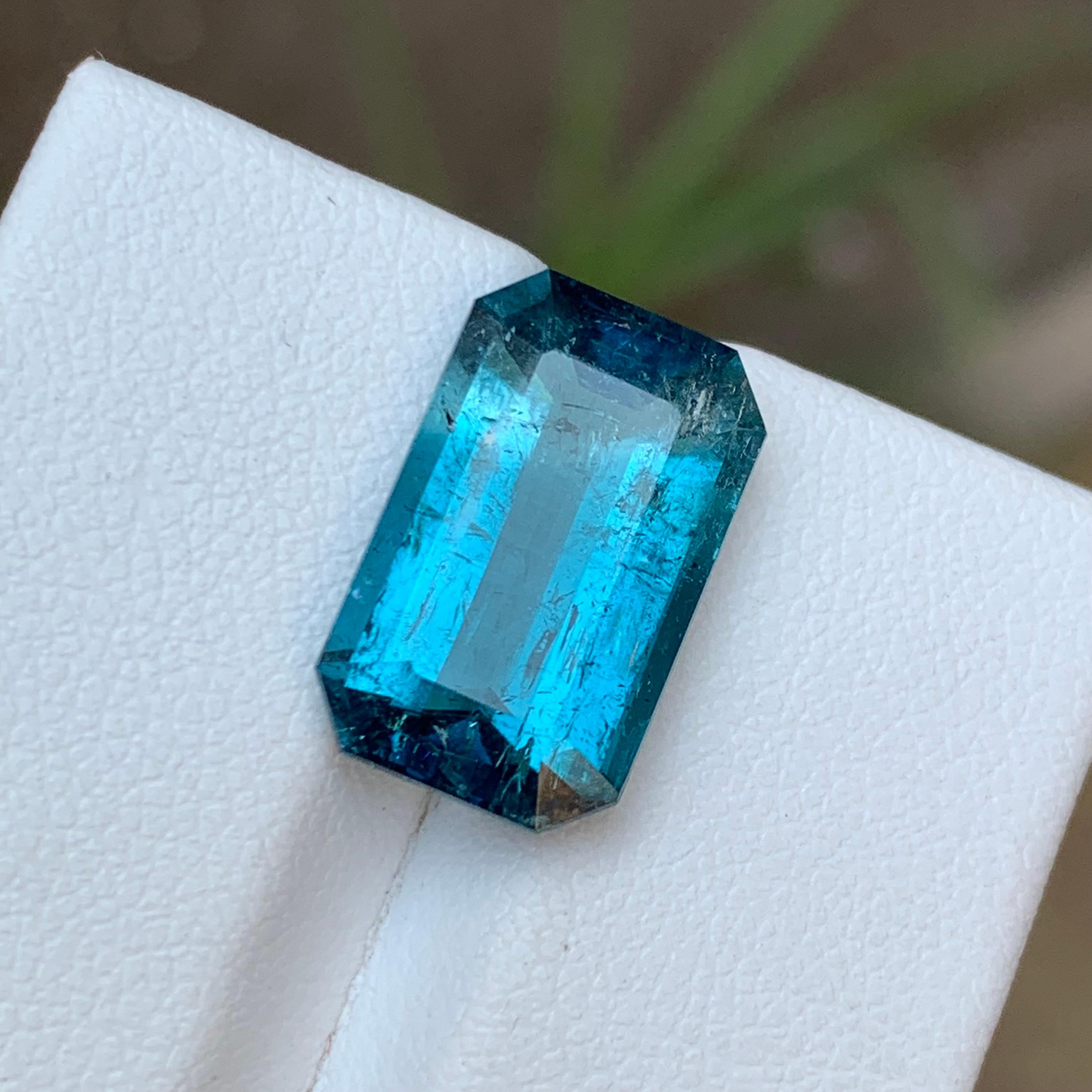GEMSTONE TYPE: Tourmaline
PIECE(S): 1
WEIGHT: 7.20 Carats
SHAPE: Emerald
SIZE (MM): 15.36 x 9.47 x 6.07
COLOR: Rich Electric Blue
CLARITY: Moderately Included 
TREATMENT: None
ORIGIN: Afghanistan
CERTIFICATE: On demand

Indulge in the ethereal