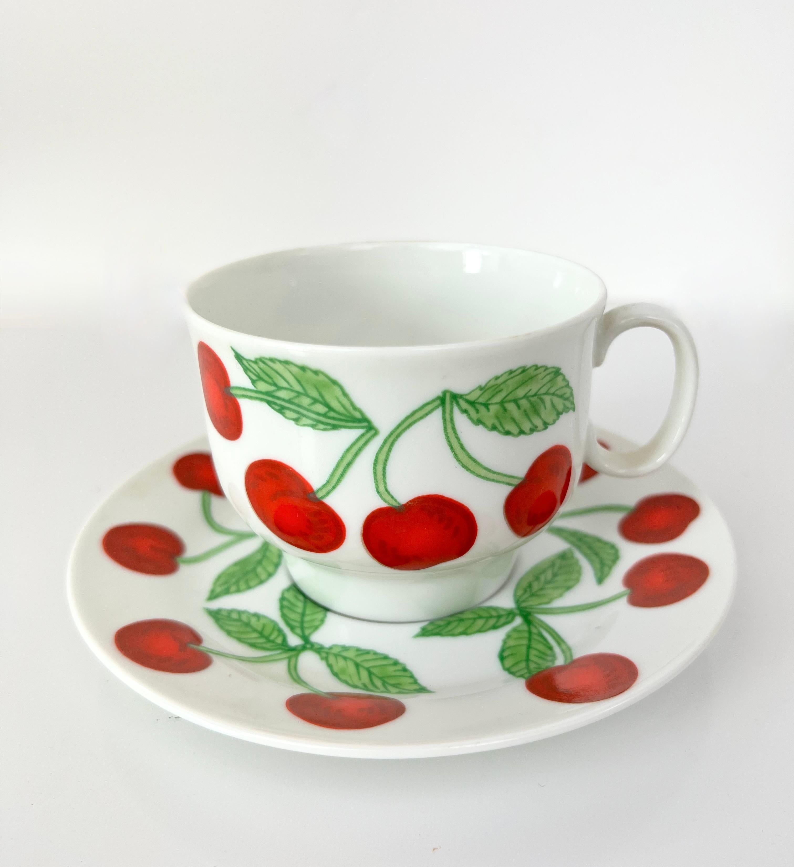 Richard Ginori porcelain coffee mug set featuring a charming bright cherry motif against a crisp white background.  Each coffee cup set includes a mug and saucer.