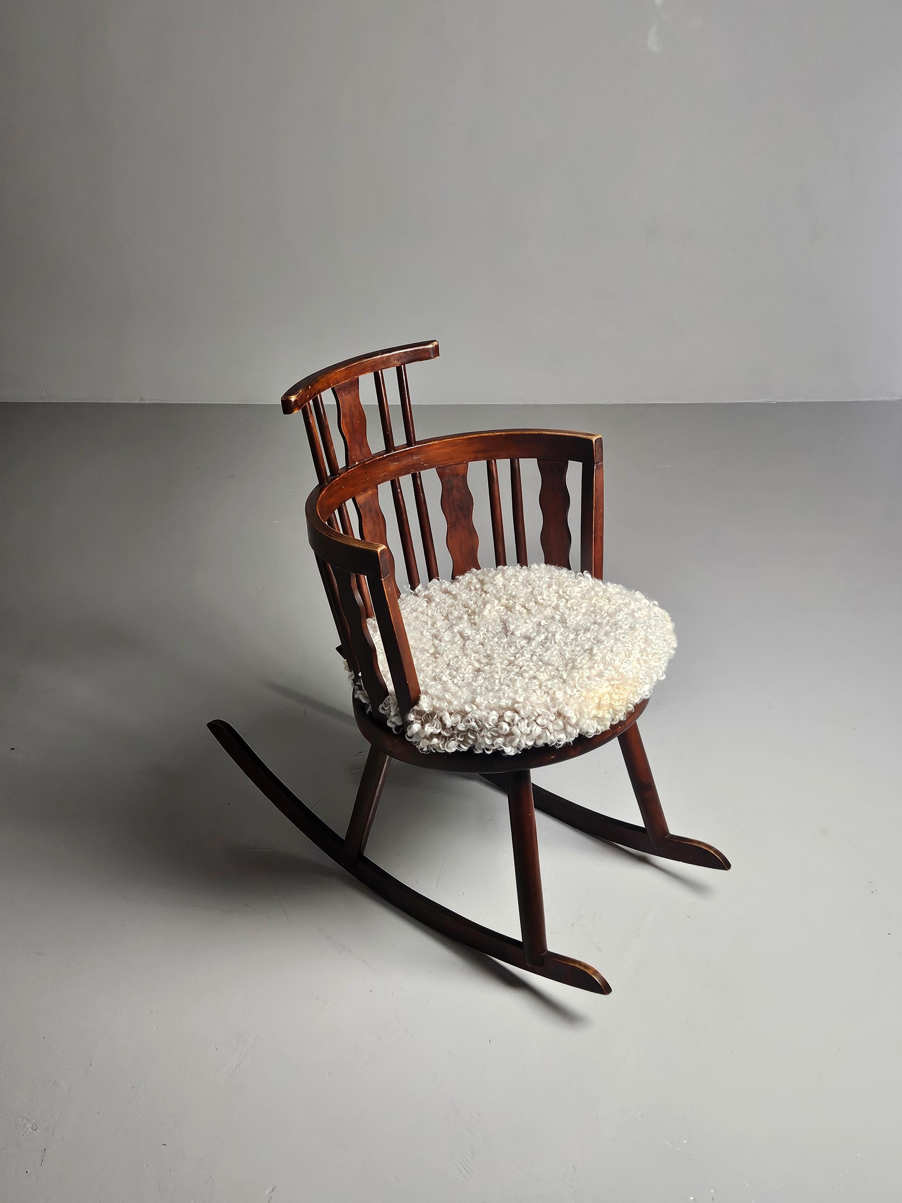 Rare rocking chair designed by Torsten Claeson who was one of the designers at Steneby Hemslöjd in the middle of the 20th century. 

Loose cushion of high quality sheepskin. 

Fits very well with other Swedish sports cabin furniture as those