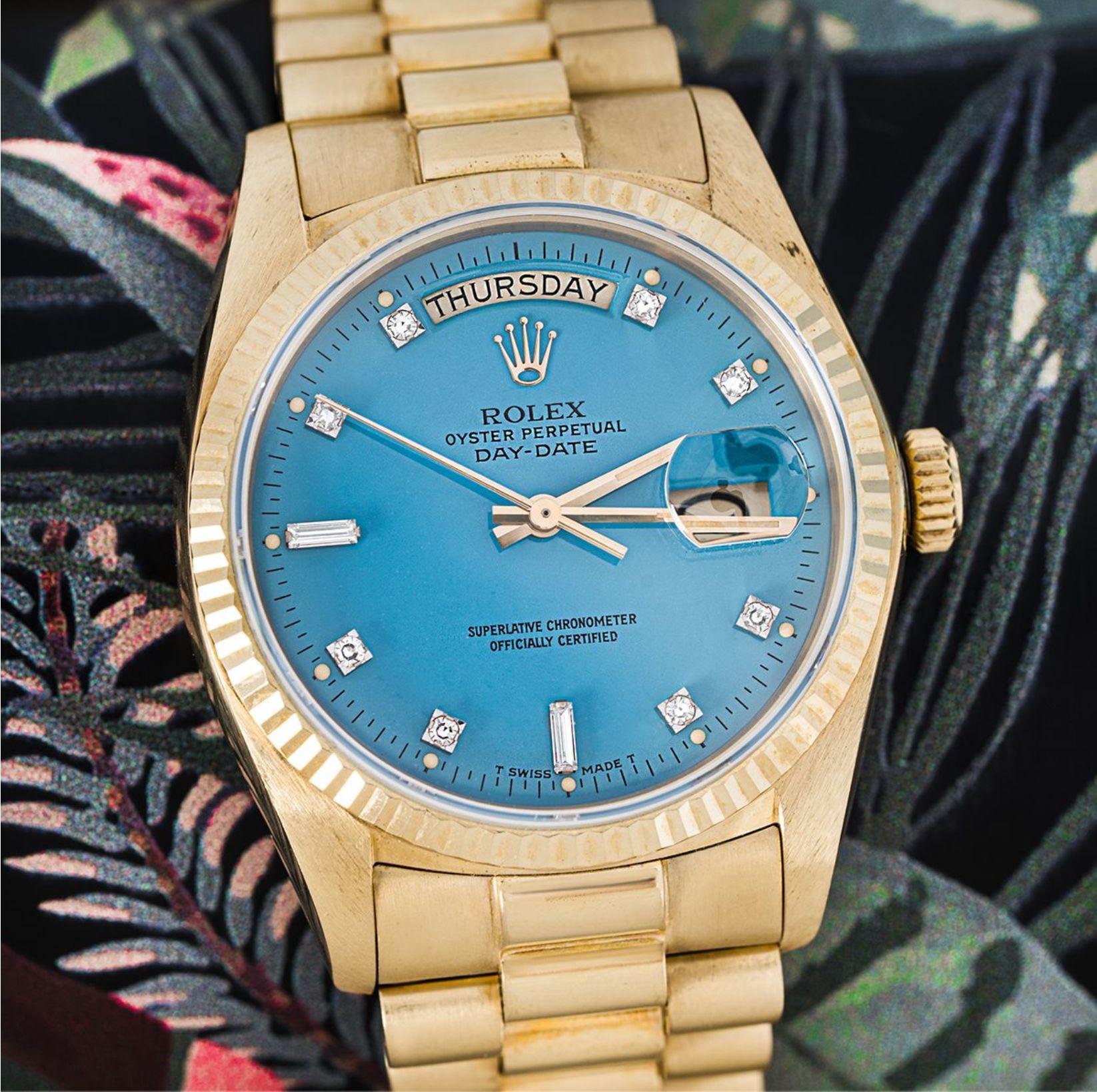 A vintage Day-Date in yellow gold by Rolex, featuring a rare turquoise Stella dial set with 2 baguette cut and 8 round brilliant cut diamond hour markers. The fluted bezel, president bracelet and concealed folding clasp are all distinctive Day-Date