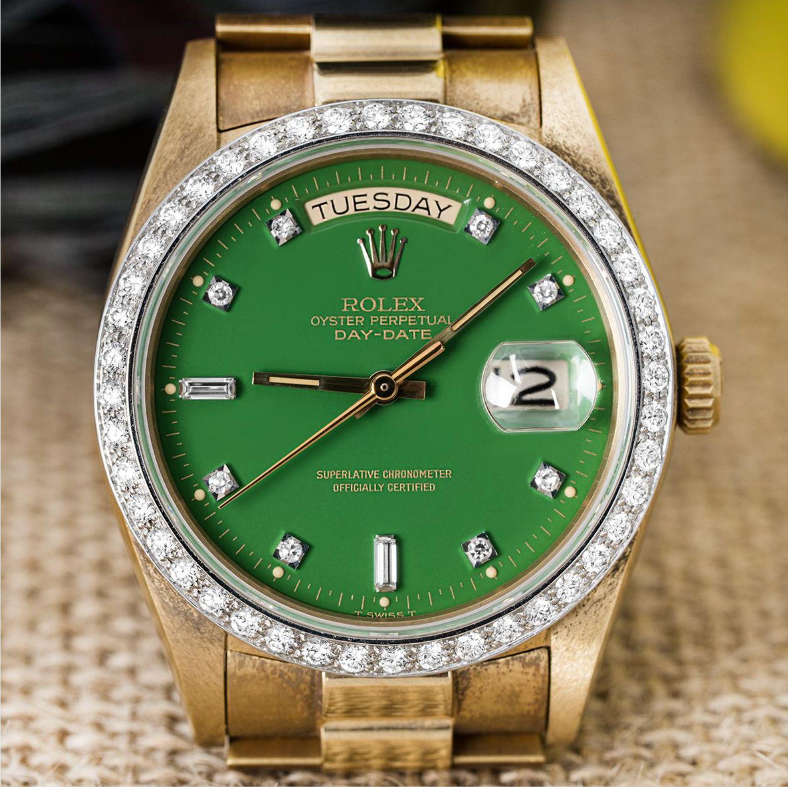 A rare NOS yellow gold Day-Date by Rolex from 1980. Featuring a stunning green Stella dial with diamond set hour markers and a fixed yellow gold fluted bezel set with 44 round brilliant cut diamonds.

The watch is fitted with a sapphire glass, a