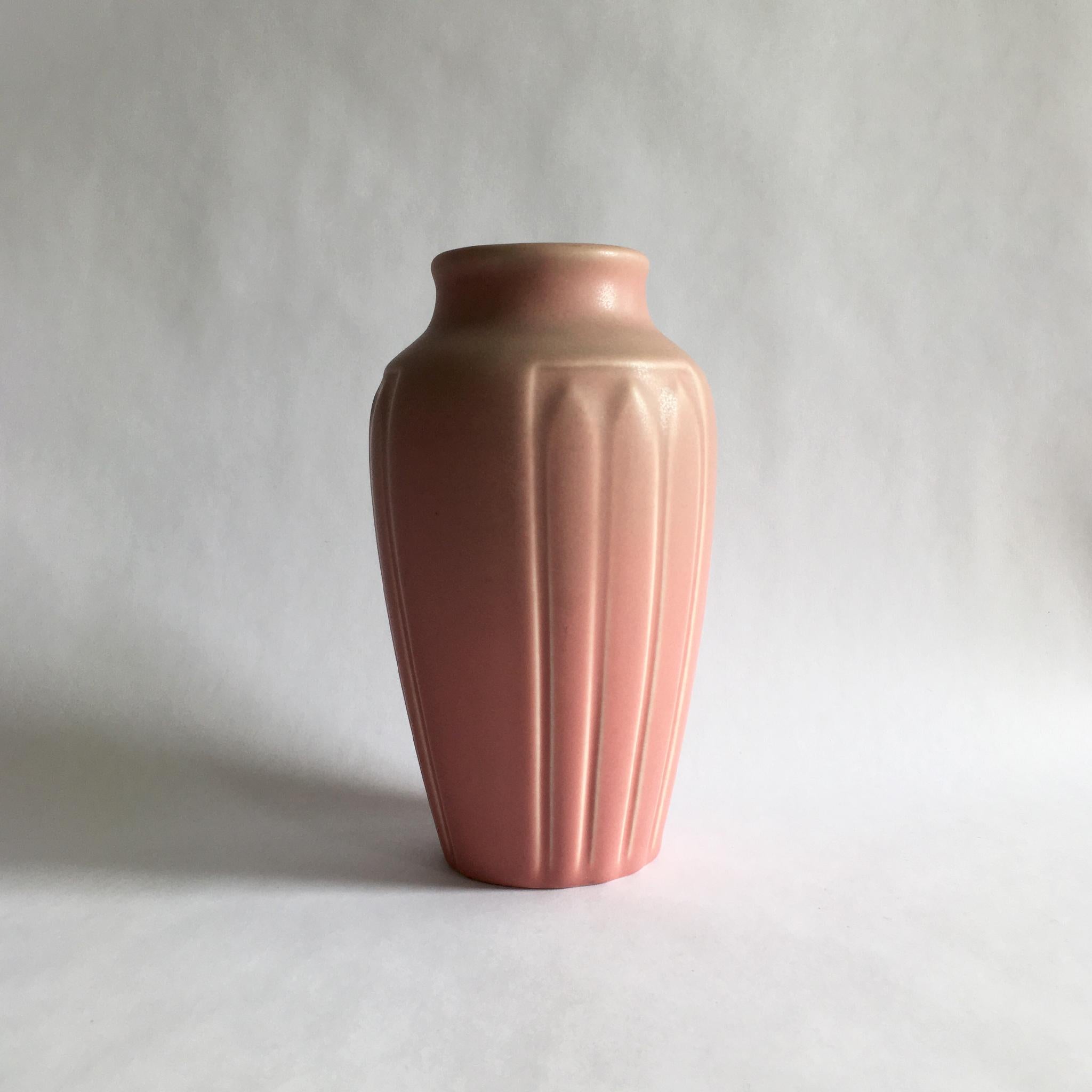 Arts & Crafts period Rookwood vase, shape 1823 in lotus leaf pattern. Matte rose glaze. Circa 1928, as marked on bottom as XXVIII.

Measures: H 7