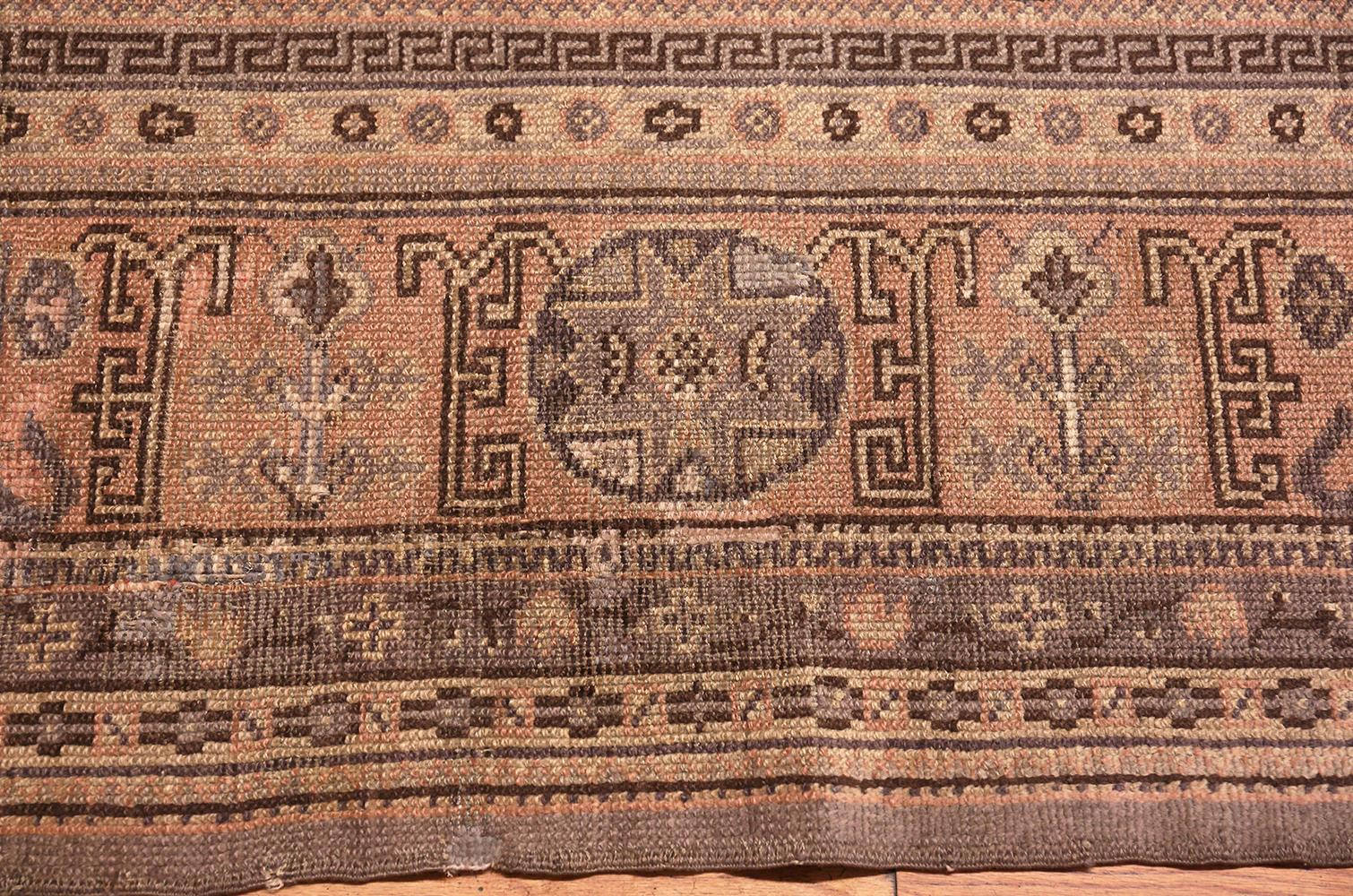 Beautifully decorative and rare larger room size antique Khotan rug, country of origin: East Turkestan, date circa turn of the 20th century. Size: 9 ft 8 in x 12 ft 7 in (2.95 m x 3.84 m)

Serrated oval medallions in soft golden tan hover across