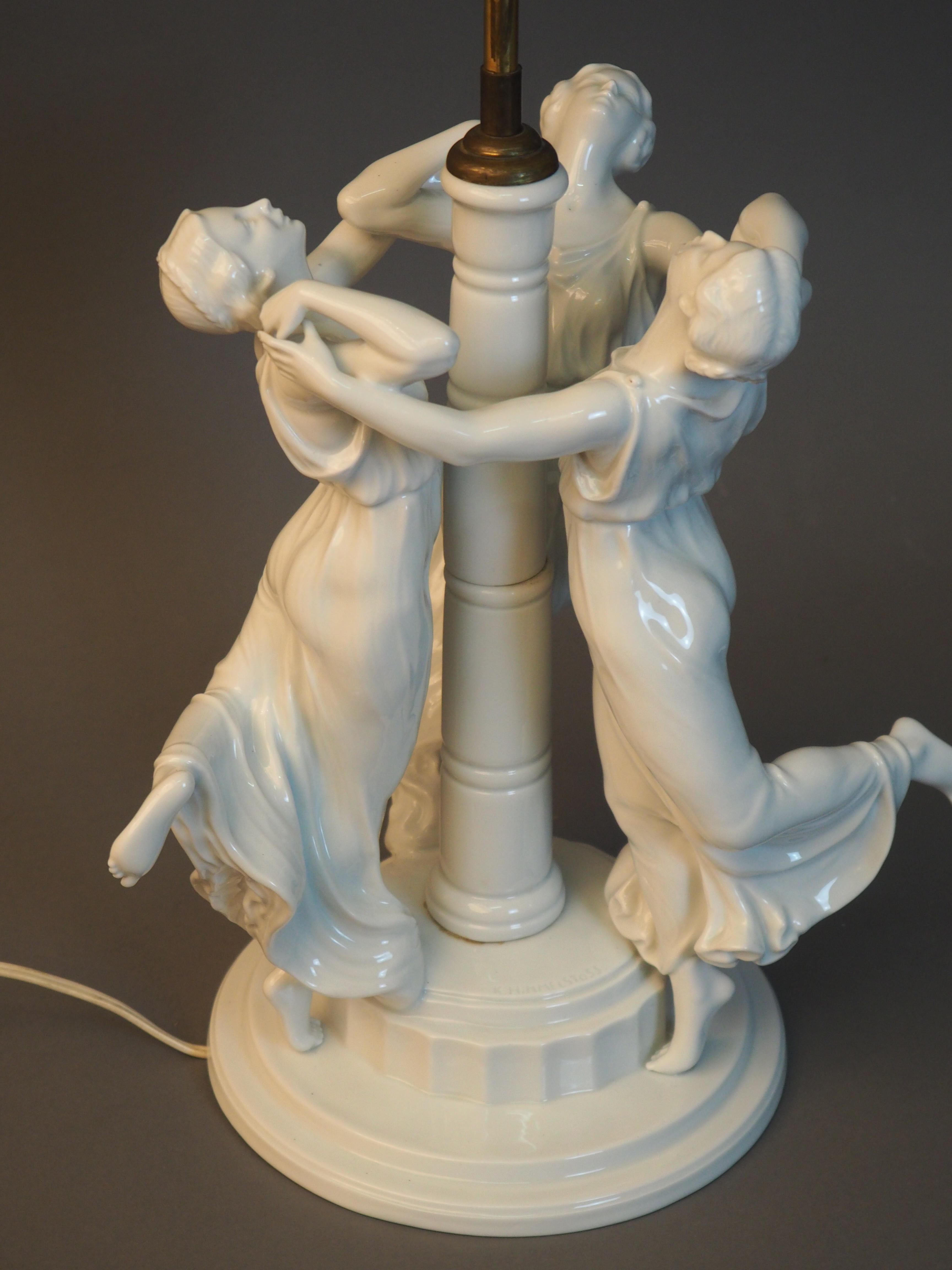 Very rare figurine group “Festreigen” table lamp, designed by Karl Himmelstoss, 1913, executed by Rosenthal, 1916.
White porcelain, three dancing graces in long robes on stepped, profiled and fluted round base, signed on the base (embossed)