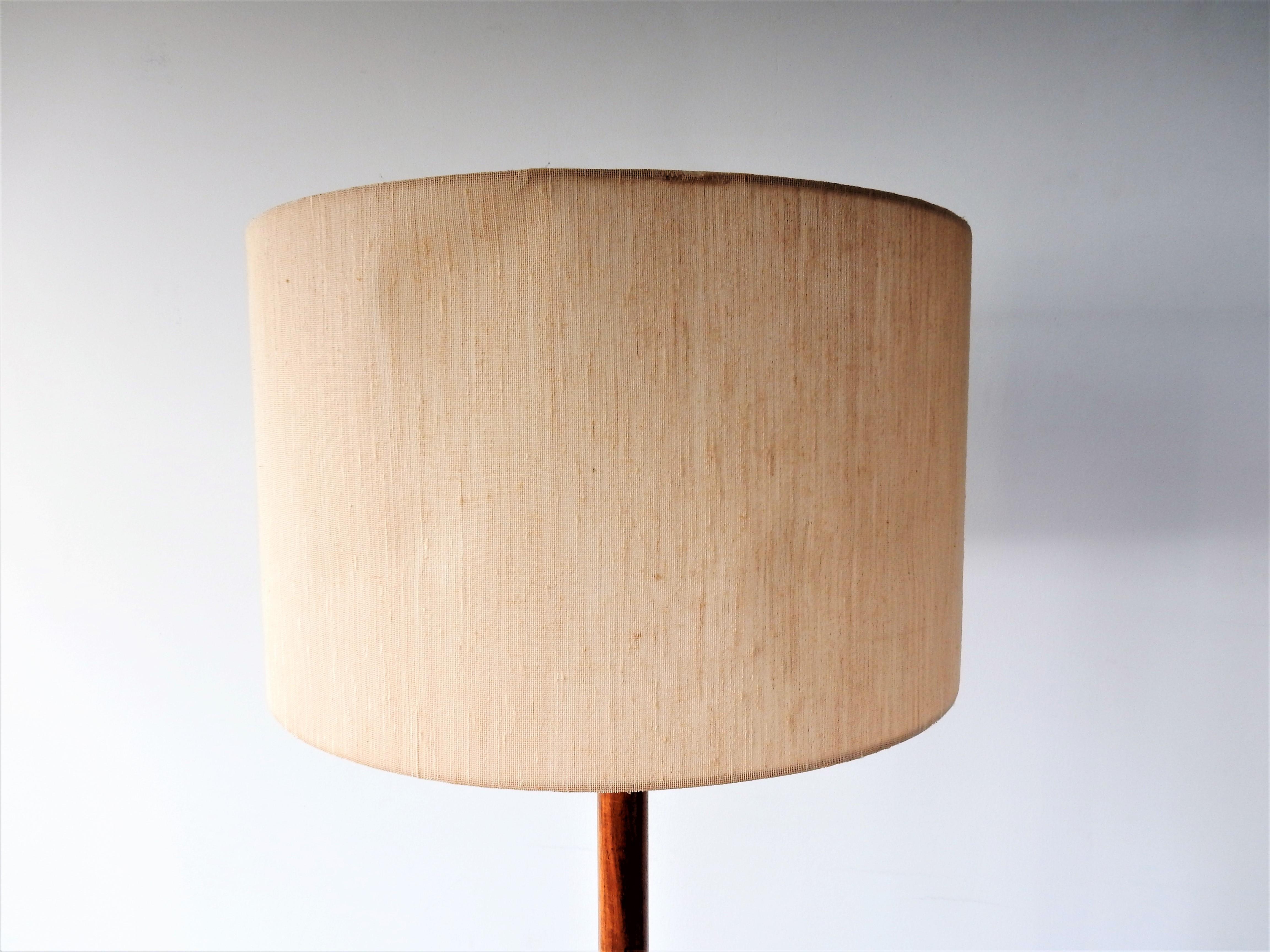 This elegant floor lamp was designed by Willem Hagoort for Hagoort Lamps in the 1960's. A lamp not often seen. It has a rosewood and metal tripod base with the original fabric shade. The shade does have a dent with a small crack to the inside, one