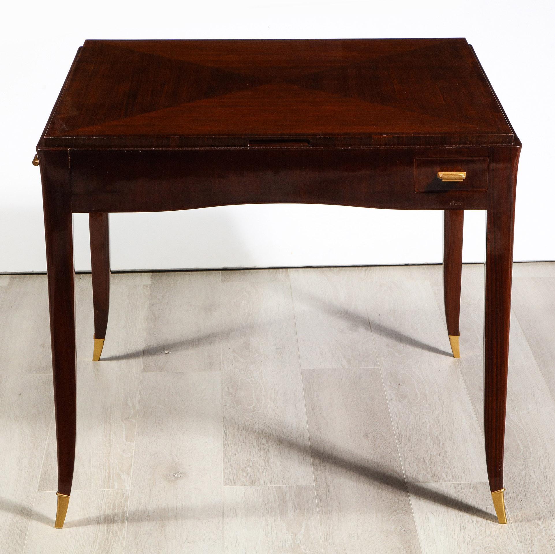 Having a quartered veneered removable top verso to show felt, the secondary top with inset storage well, the slightly concave apron with drinks drawers and gilt bronze pulls the tapered saber legs with gilt bronze sabots
Branded Ruhlmann
Model No.