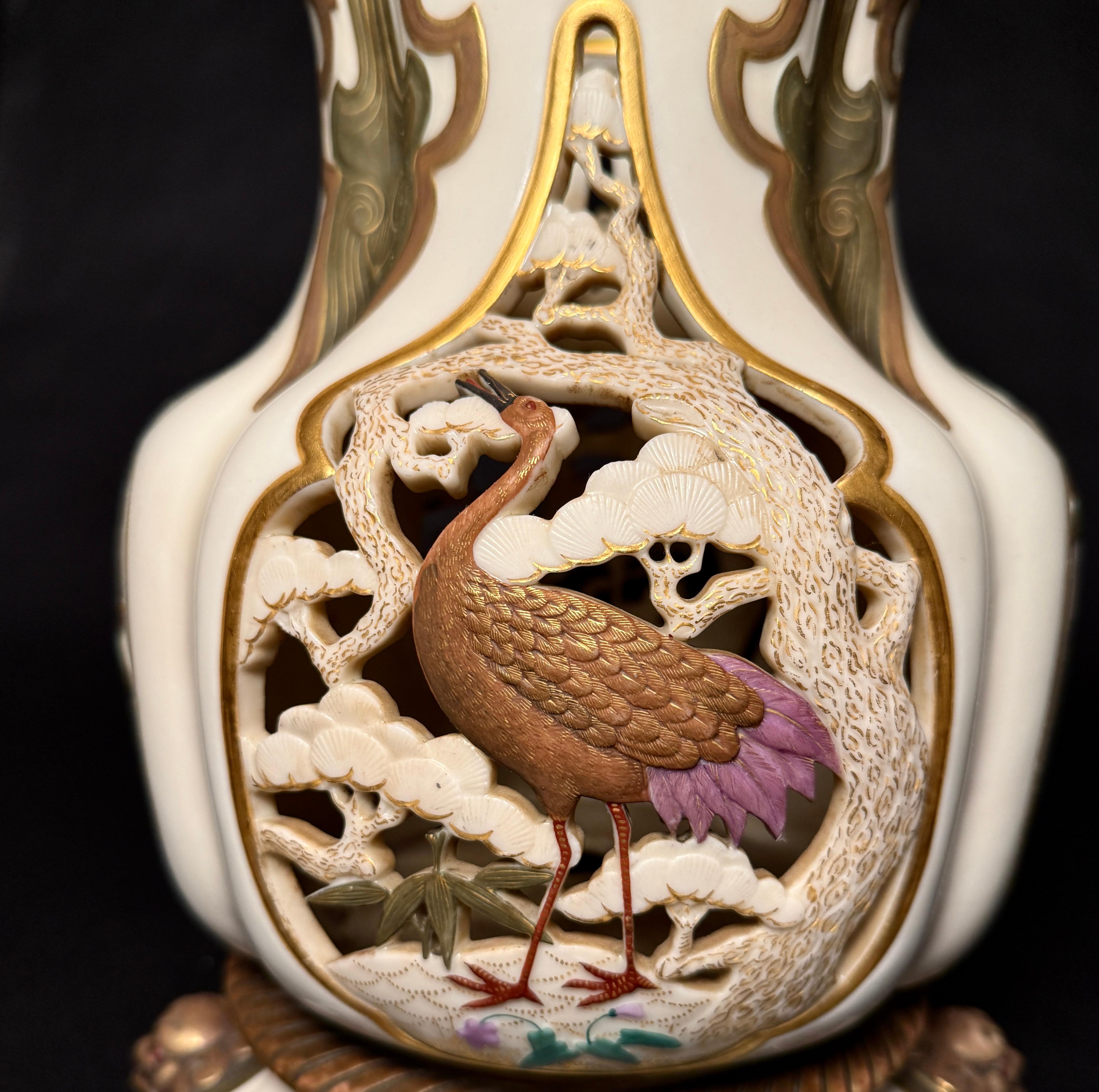 Exotic antique Royal Worcester vase on stand, decorated with cranes, flowers, bamboo and trees on the main body with reticulated see-through and relief panels. With gargoyle masks and jeweled rosettes on the base. This is a museum/exhibition quality