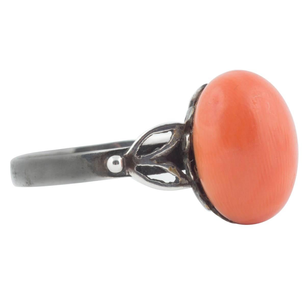 From the Romanov era, a distinctive Russian silver ring set with an oval orange coral from the Black Sea. The coral measures approximately 13 x 10 x 8 mm (l x w x h) and is of a fine quality and uniform colour. Of typical Russian design with leaf