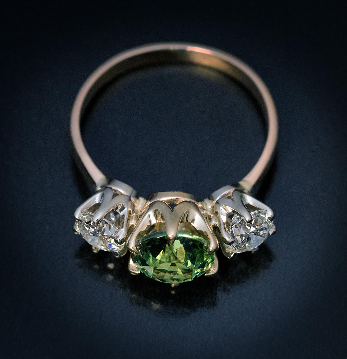 Circa 1950s

A vintage Russian 14K gold three-stone ring is centered with a rare 1.96 ct brilliant cut demantoid from the Ural Mountains of an excellent golden green color. The center stone is flanked by two o.51 ct bright white diamonds (G color,