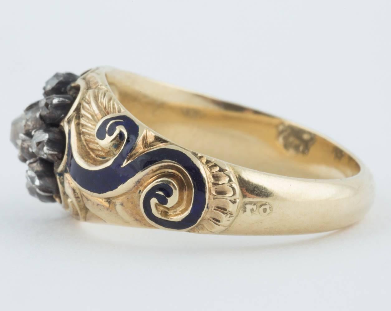 A rare Russian mid-19th century gentleman's ring from the Romanov era, period of Tsar Nicholas I, set with an old-mine-cut diamond surrounded by eight smaller full cut diamonds on silver, the 18k gold ring enhanced with cobalt blue enamel scrolls