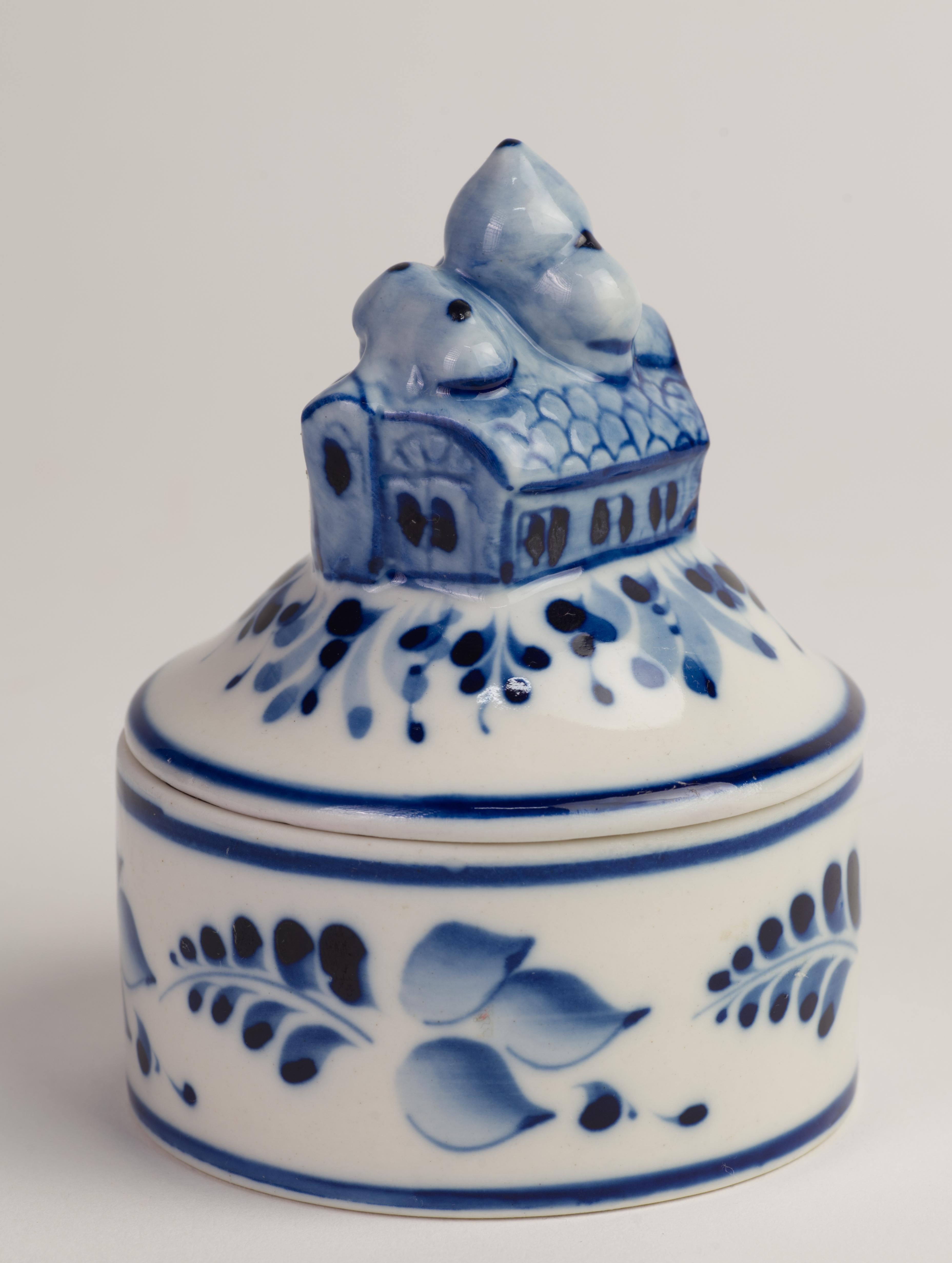 Rare small lidded trinket box with church-shaped handle on the lid is hand painted in two tone blue on white porcelain background. Floral decor on the body of the box and on the lid, irradiating from the center, appears to be heavily influenced by