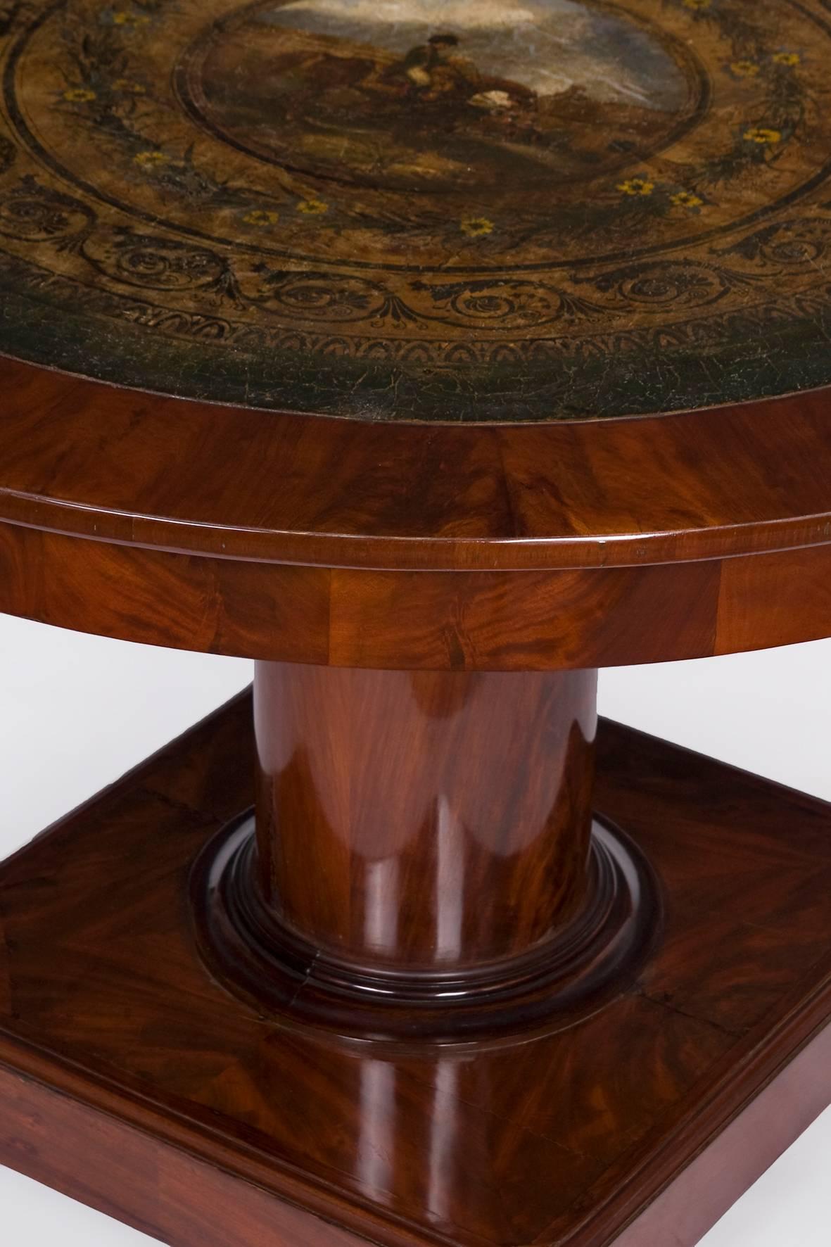 A rare saloon table from Belgium with a painting. The foot is a square pedestal mounted on rollers. On the feet is the solid pillar, which is carrying the plate, located. The cover plate is veneered with mahogany and an oil painting on coarse canvas