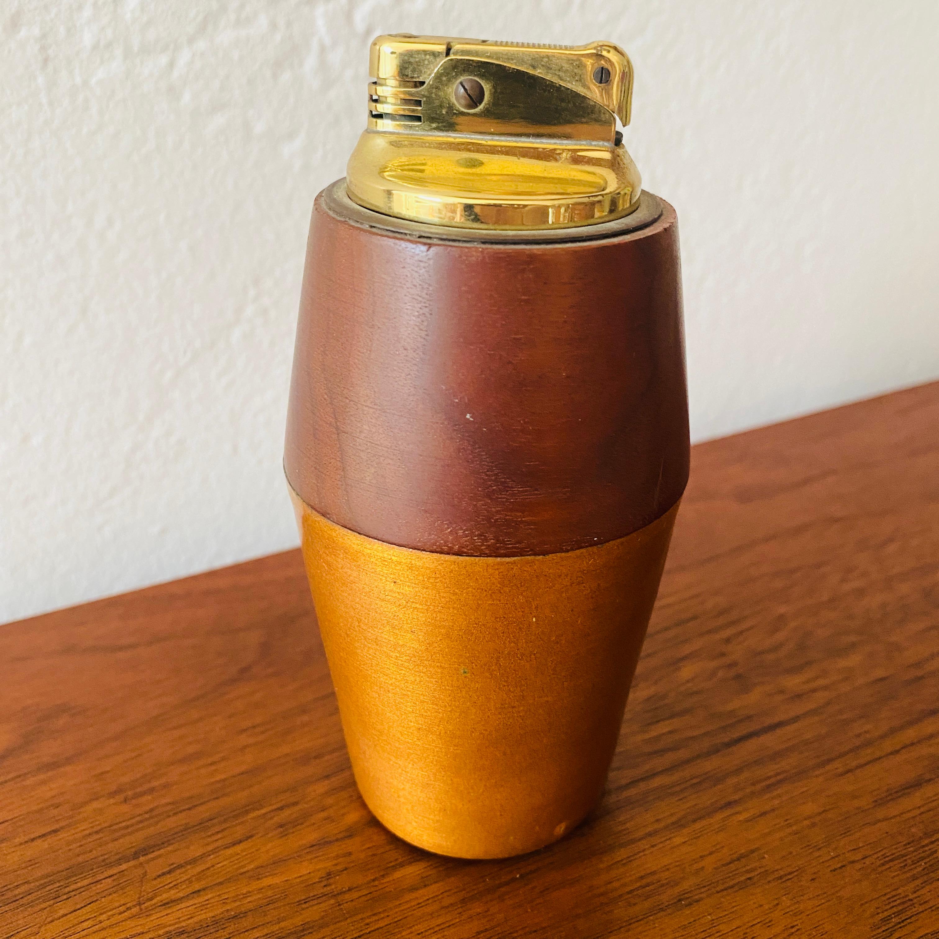 This is a rare mid-century modern lighter made by Sascha Brastoff. The lighter is made of walnut, atomic orange enameled metal, and a W. Germany inserted lighter. You simply remove the lighter to add lighter fluid. The bottom of the base is signed