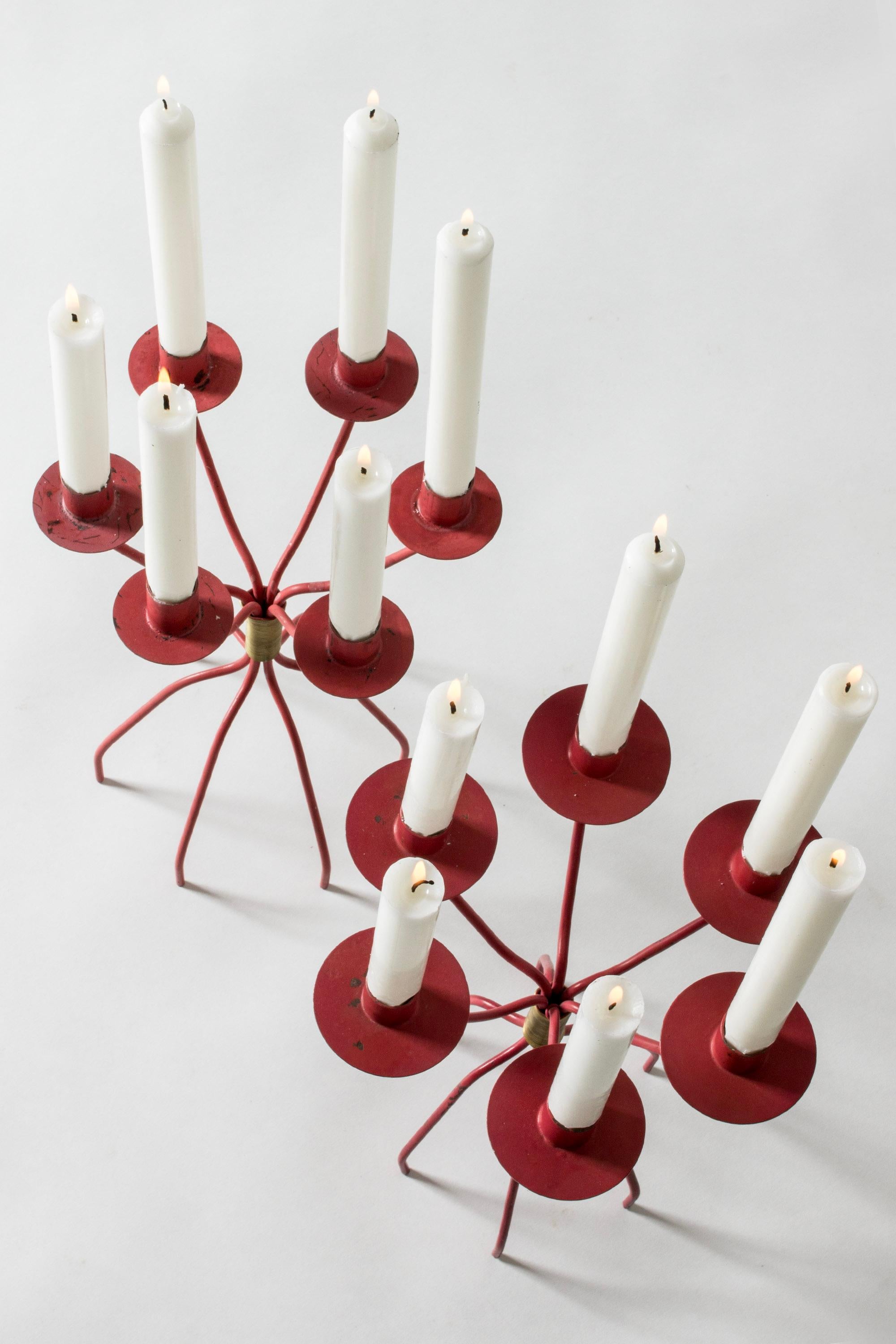 Paire de candélabres étonnants au design ludique de Hans-Agne Agnes, avec six bras chacun. Laqué rouge, détails décoratifs en laiton. Le diamètre des manchettes varie légèrement d'un modèle à l'autre.