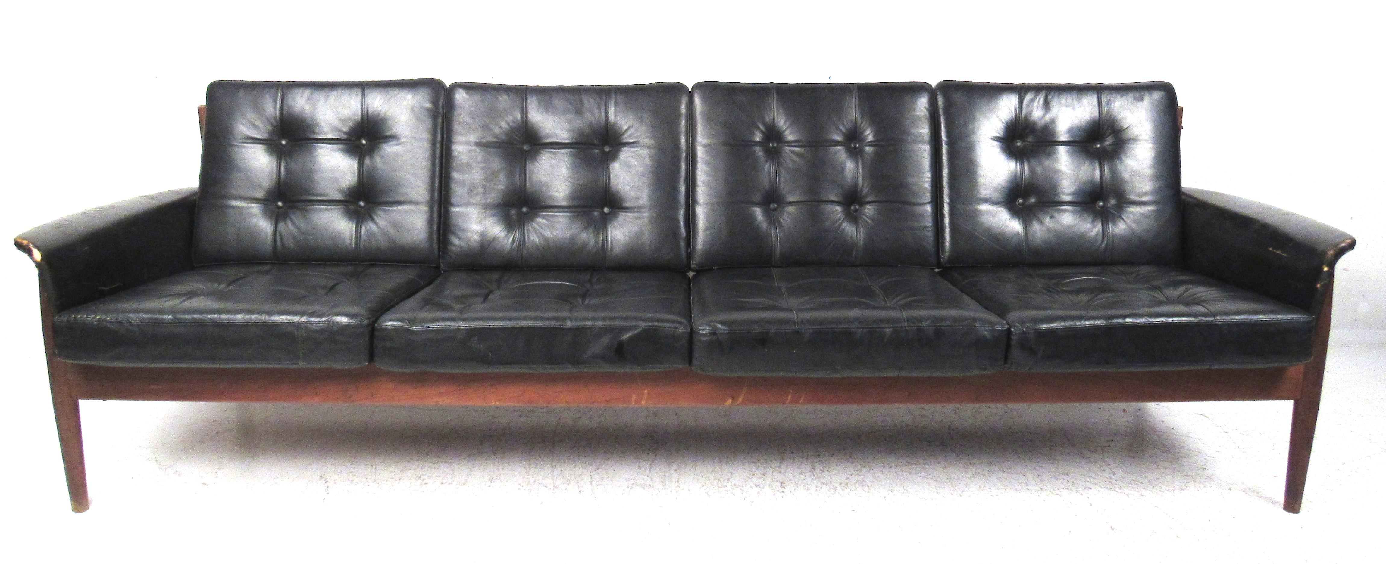 Das Sofa Modell 168/4 wurde 1962 von Charles 'Fearnley' France, dem Chef von France & Son, entworfen. Produziert
Dieses Sofa aus massivem Teakholz mit schwarzem Lederbezug ist identisch mit einem von Grete Jalk entworfenen Sofa, mit Ausnahme der