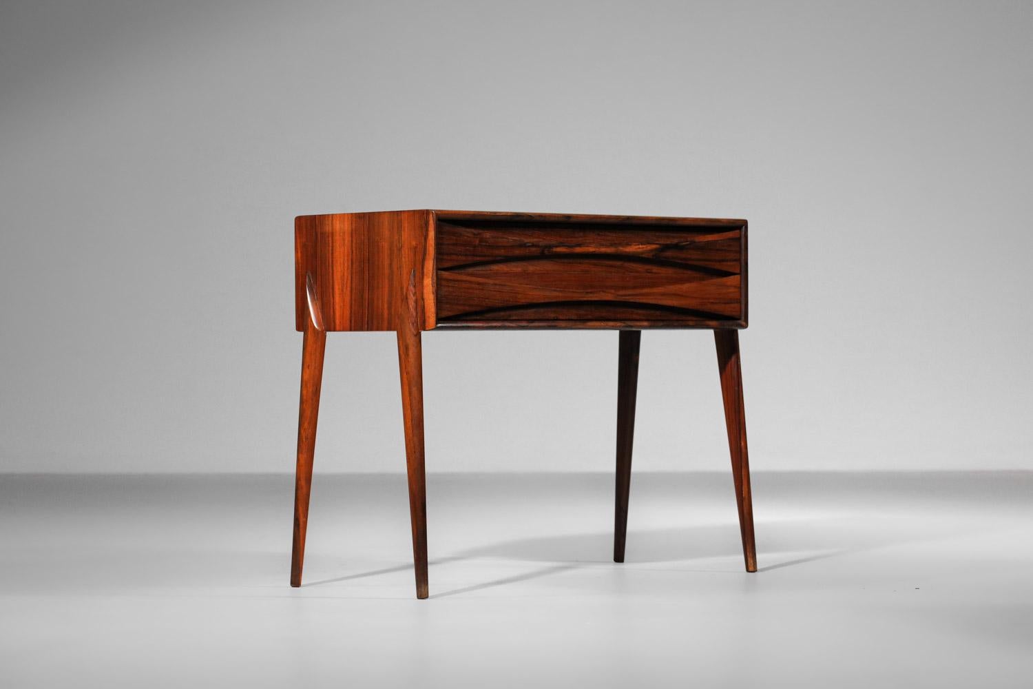 Bedside table from the 60s by Danish designer Arne Vodder. This bedside table is entirely in solid Rio rosewood and veneered. The two drawers are beautifully finished with full-length wooden handles. Sober, uncluttered design typical of Scandinavian
