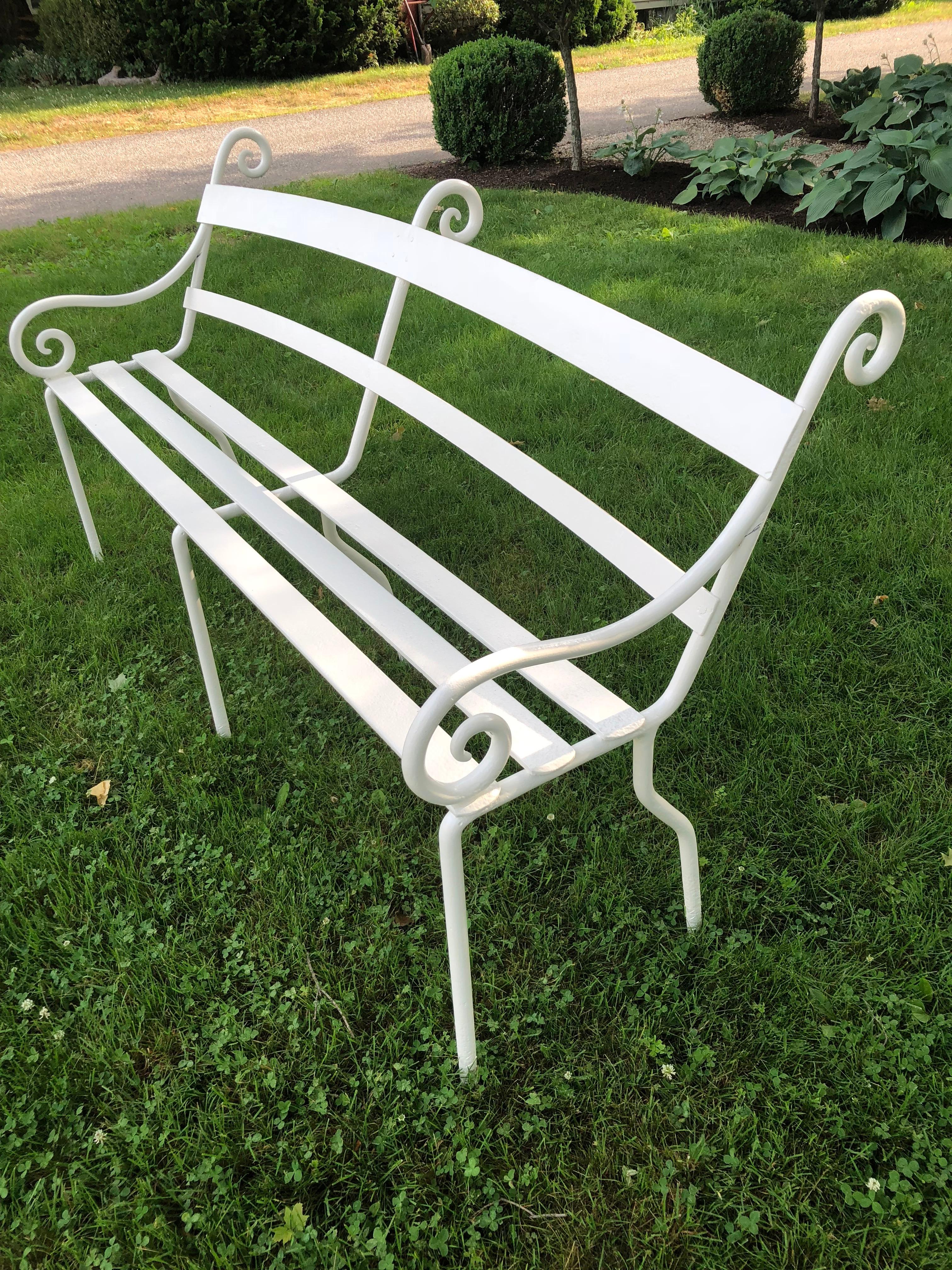 This rare and exceptional late Regency bench is both elegant and unusual in form. It is constructed of very heavy hand-forged wrought iron with a canted back that makes for very comfortable seating. The bold scrolled ears and arm supports make this