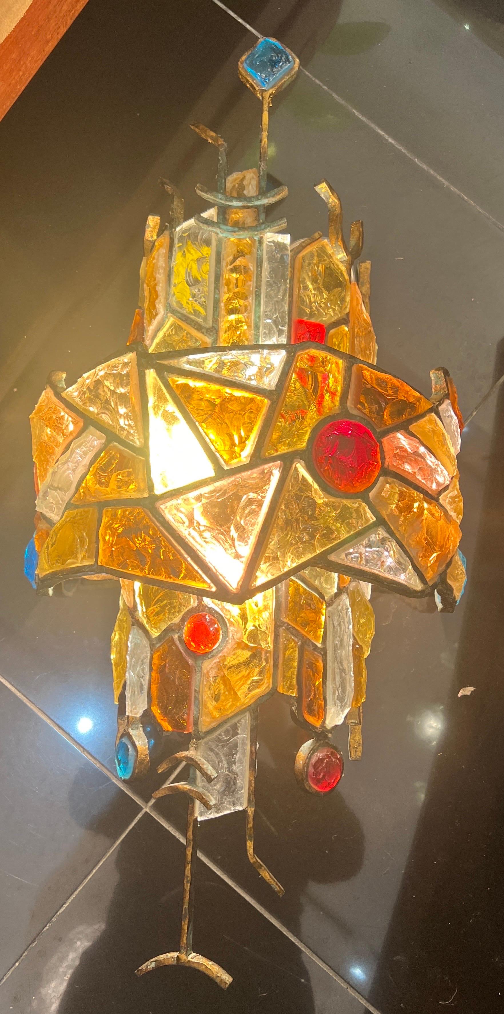 Eine große skulpturale Wandleuchte aus vergoldetem Eisen mit mehrfarbigem Glas, das jeweils in einen Metallrahmen verschiedener Formen und Größen eingesetzt ist.
Entworfen von Albano poli 
Hergestellt von poli Arte 
C1960
Italien  