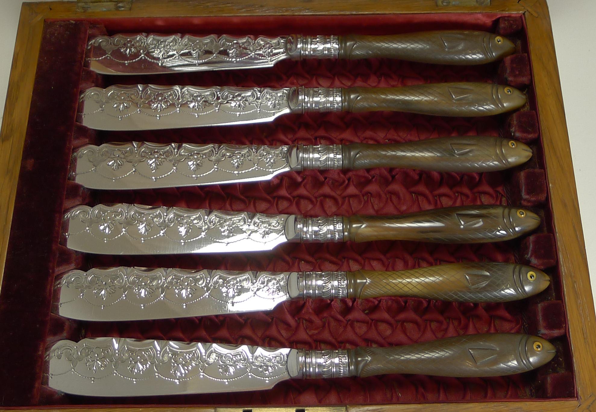 Édouardien Ensemble rare de couteaux et de fourchettes à poisson, poignées sculptées figuratives avec yeux en verre, 1909 en vente
