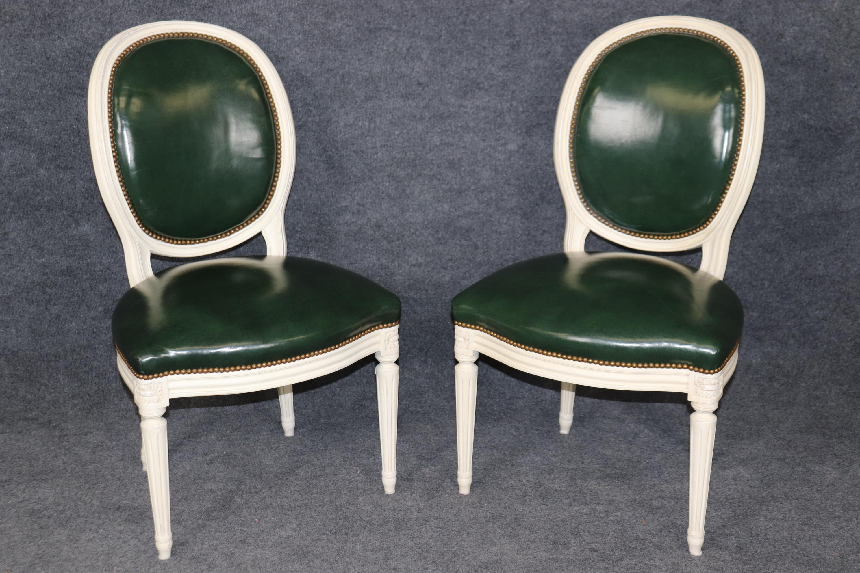 Si tratta di un ottimo set di 10 sedie da pranzo in stile Maison Jansen, verniciate in verde e rivestite in vera pelle verde scuro. La pelle è in ottime condizioni con i minimi segni dell'età e dell'uso e le cornici dipinte sono nitide e brillanti.