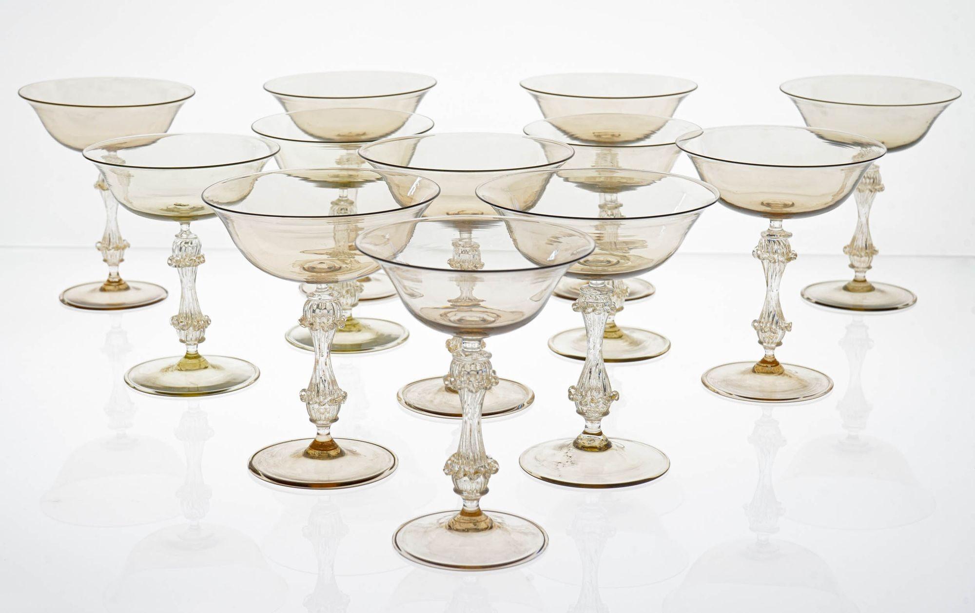 This exceptional set of 12 vintage champagne glasses is a rare and unique find.

Handmade in Murano, Italy by Cenedese, one of the most renowned glassmakers of the time, these glasses are a masterpiece of craftsmanship.

The glasses are made of