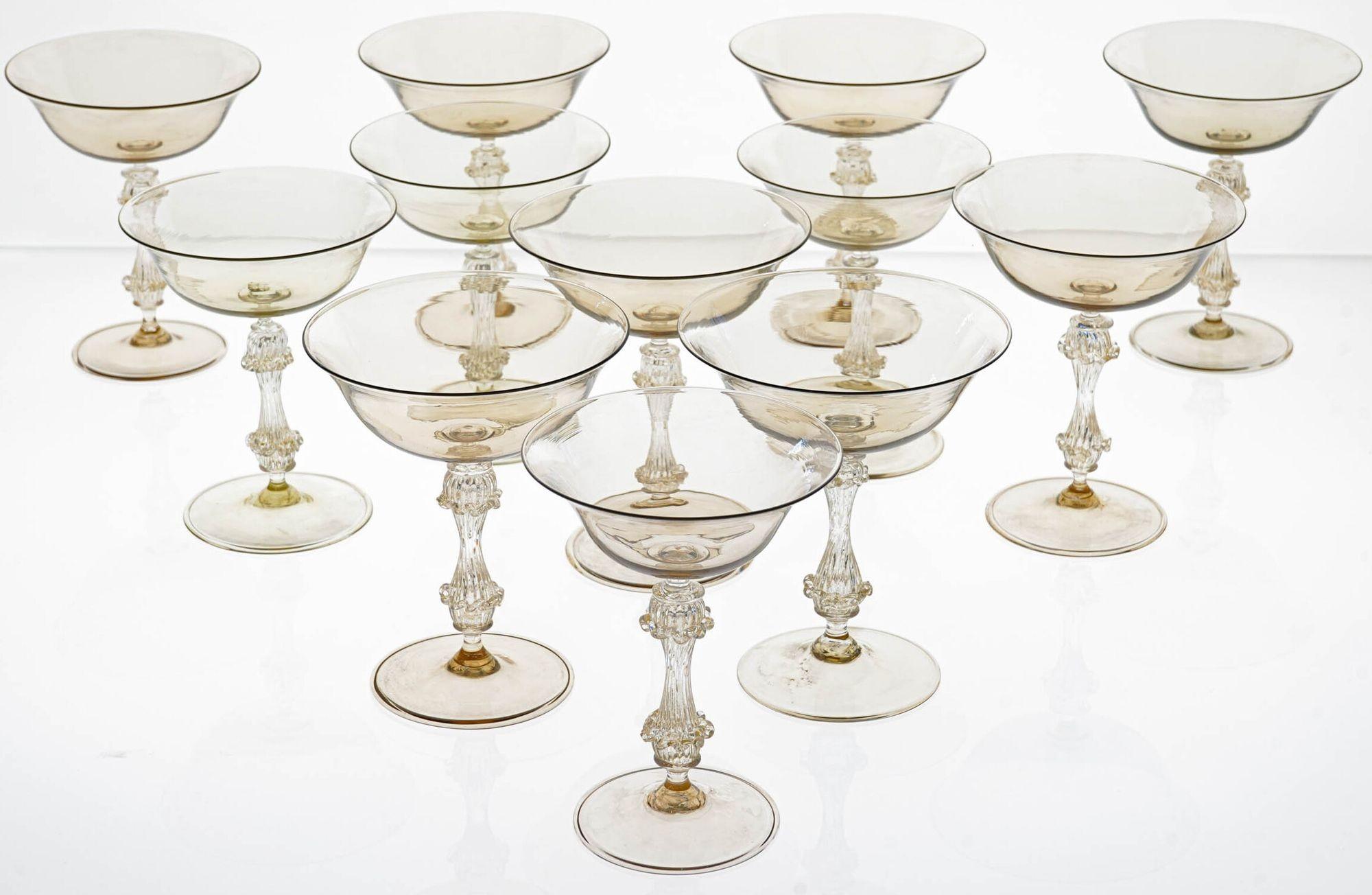 This exceptional set of 12 vintage champagne glasses is a rare and unique find.

Handmade in Murano, Italy by Cenedese, one of the most renowned glassmakers of the time, these glasses are a masterpiece of craftsmanship.

The glasses are made of