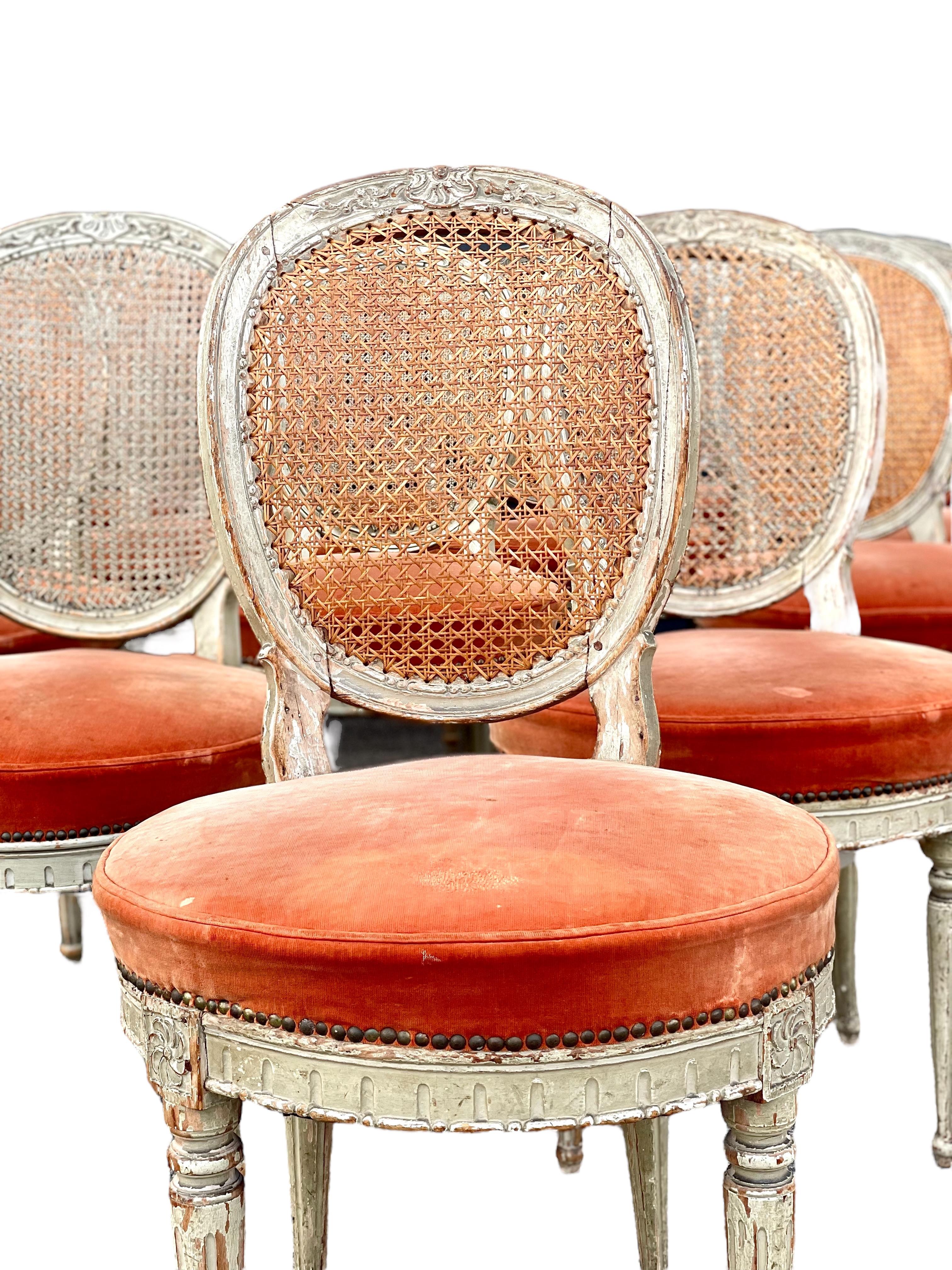 This exceptional set of 14 Louis XVI period chairs embodies the timeless elegance of the late 18th century. Featuring a refined and classic design, these chairs are crafted from carved wood with an exquisite oval medallion backrest in woven cane, a