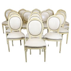 Rare ensemble de 16 chaises de salle à manger françaises Louis XVI à dossier camée peint en crème sculptée 