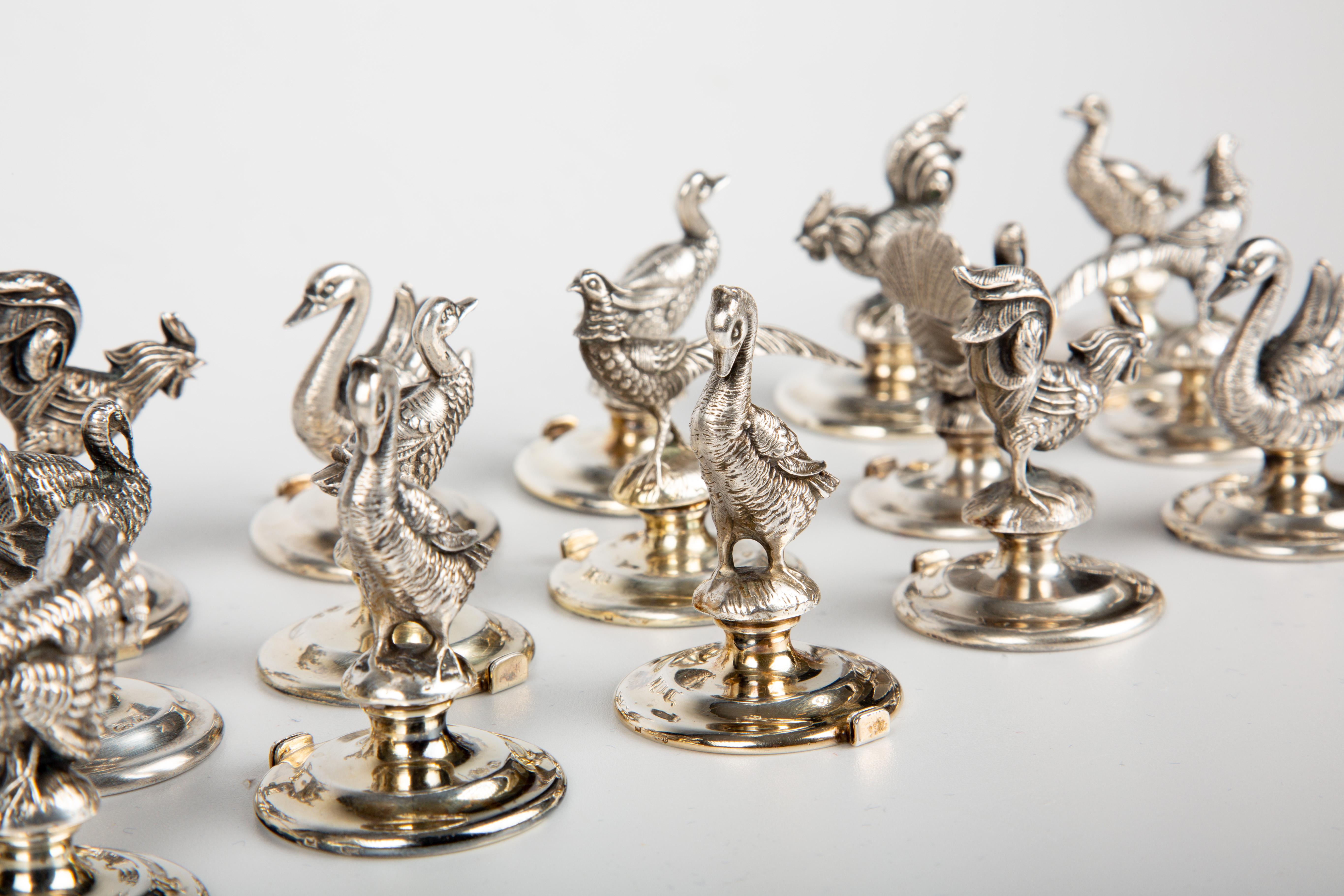 This exquisite collection comprises an exceptionally rare set of 18 Italian silver place card holders, each meticulously designed in the likeness of various avian species, including Turkeys, Pheasants, Quails, Ducks, Chickens, and Swans. These