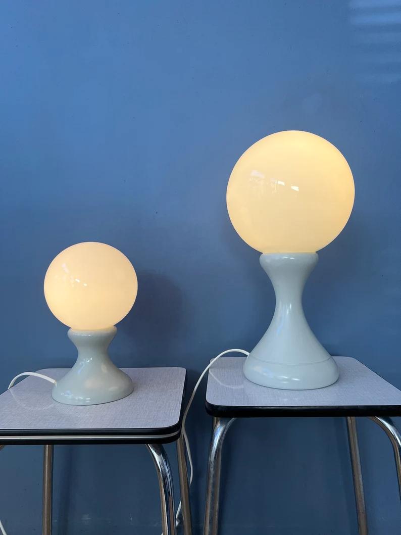 Very rare set of 2 white space age table lamps with milk glass shades. Each piece consist of a wooden base with white lacquer and a milk glass shade. They require a E14 lightbulb each and currently have EU-plugs (works outside EU with different plug