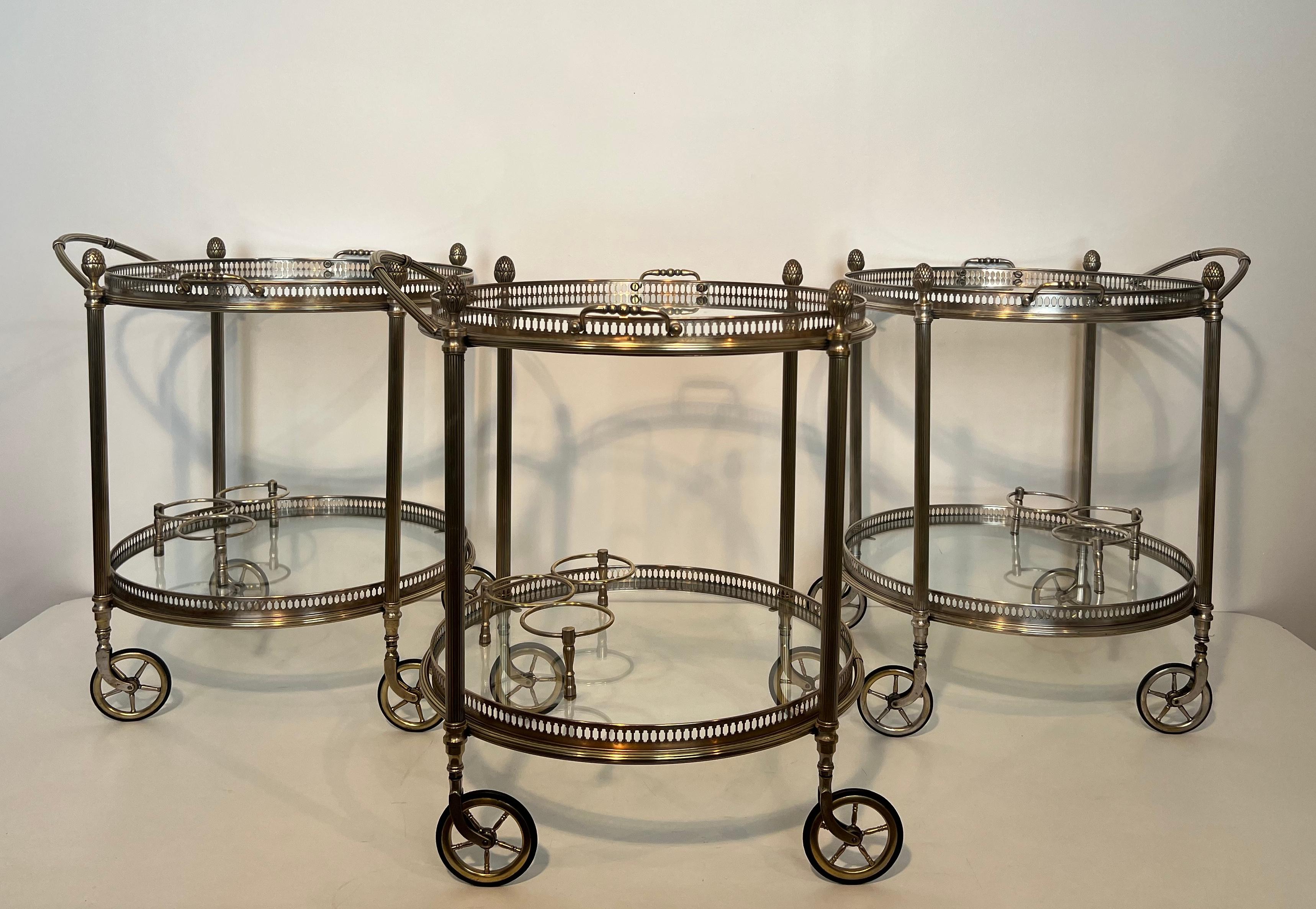 This very nice and rare set of Three neoclassical Style Round Bar Carts is Made of Silvered Brass with removable trays. This is a French work by Maison Bagués. Circa 1940