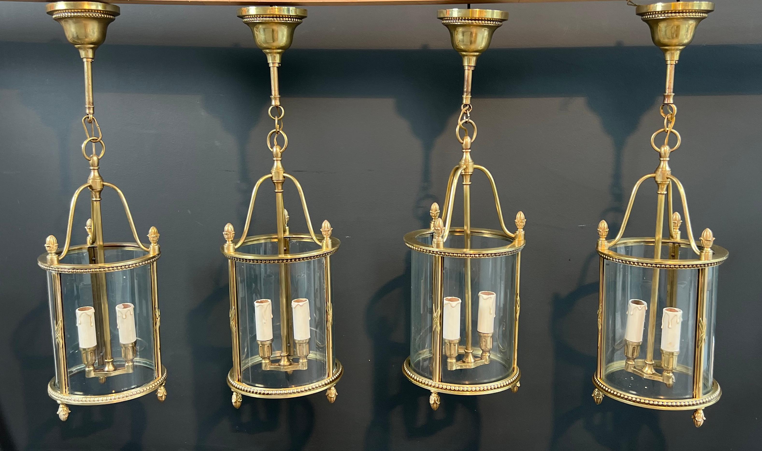 Raro set di 4 lanterne rotonde in bronzo in stile neoclassico. Lavoro francese  attribuita alla Maison Jansen. Circa 1940.
L'altezza totale con la catena e il baldacchino è di 26 pollici (66 cm), ma è possibile aggiungere una catena.
