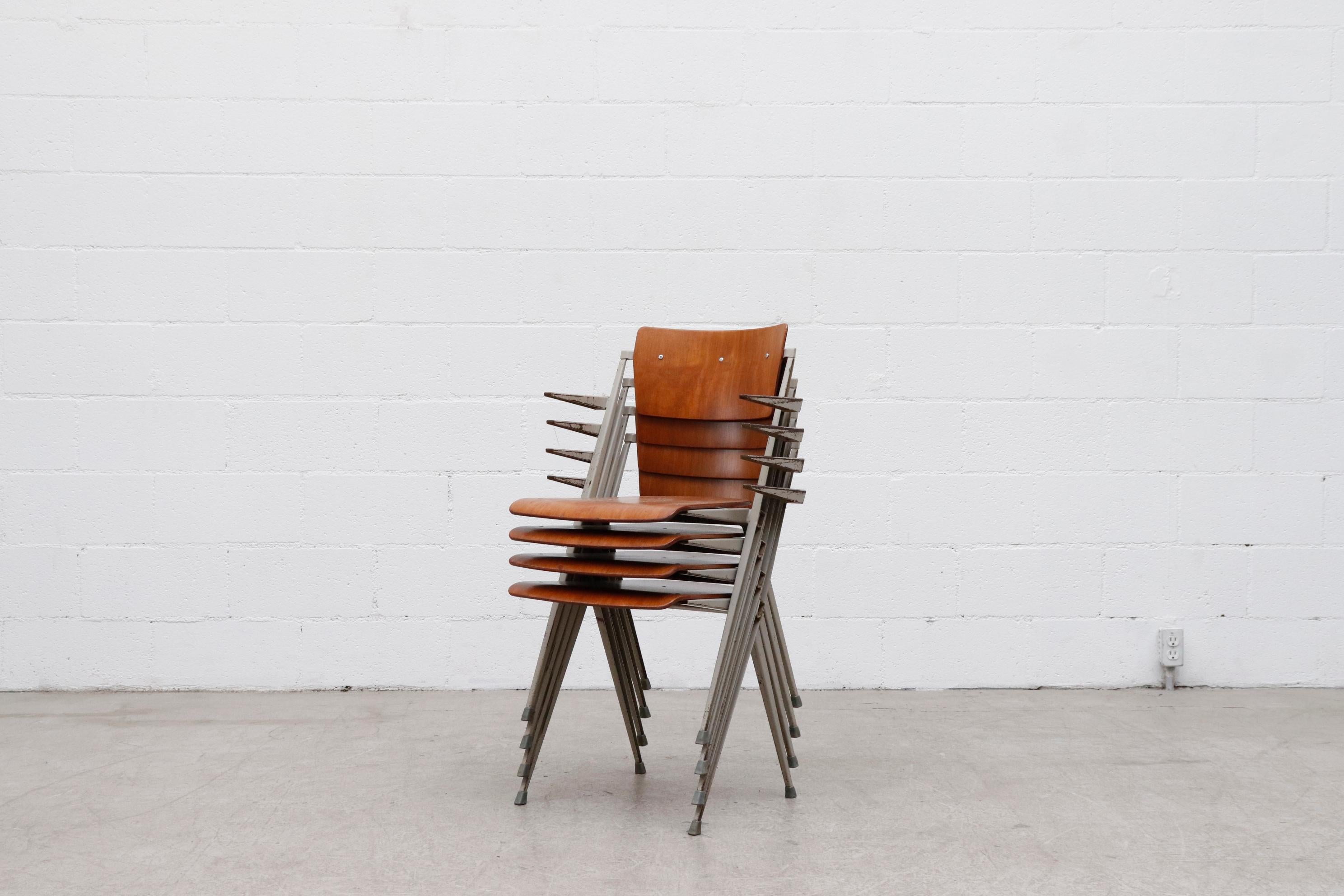 Amazing and rare set of 4 Wim Rietveld stacking 'Pyramid' armchairs. Extremely durable and comfortable with grey enameled metal frames and arms rests. Formed teak seat and backrest Riveted to the folded sheet metal frames. These 1960 ‘Signe D’or’