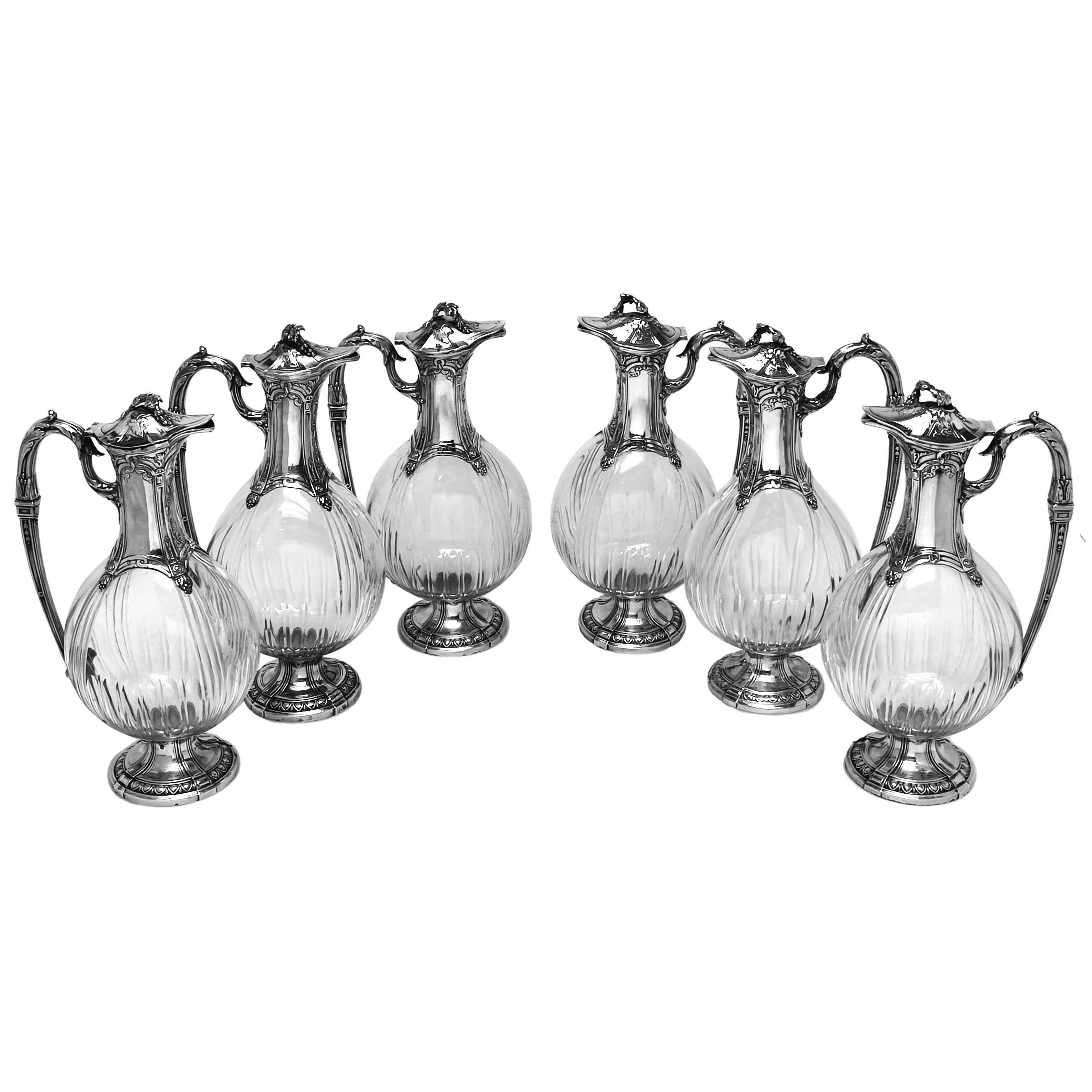 Un raro e magnifico set di 6 caraffe da Claret montate in argento con corpo in vetro trasparente. Ogni brocca antica presenta un bellissimo motivo cesellato sul collo, sul manico, sul coperchio e sul piede. Ogni manico presenta una decorazione a