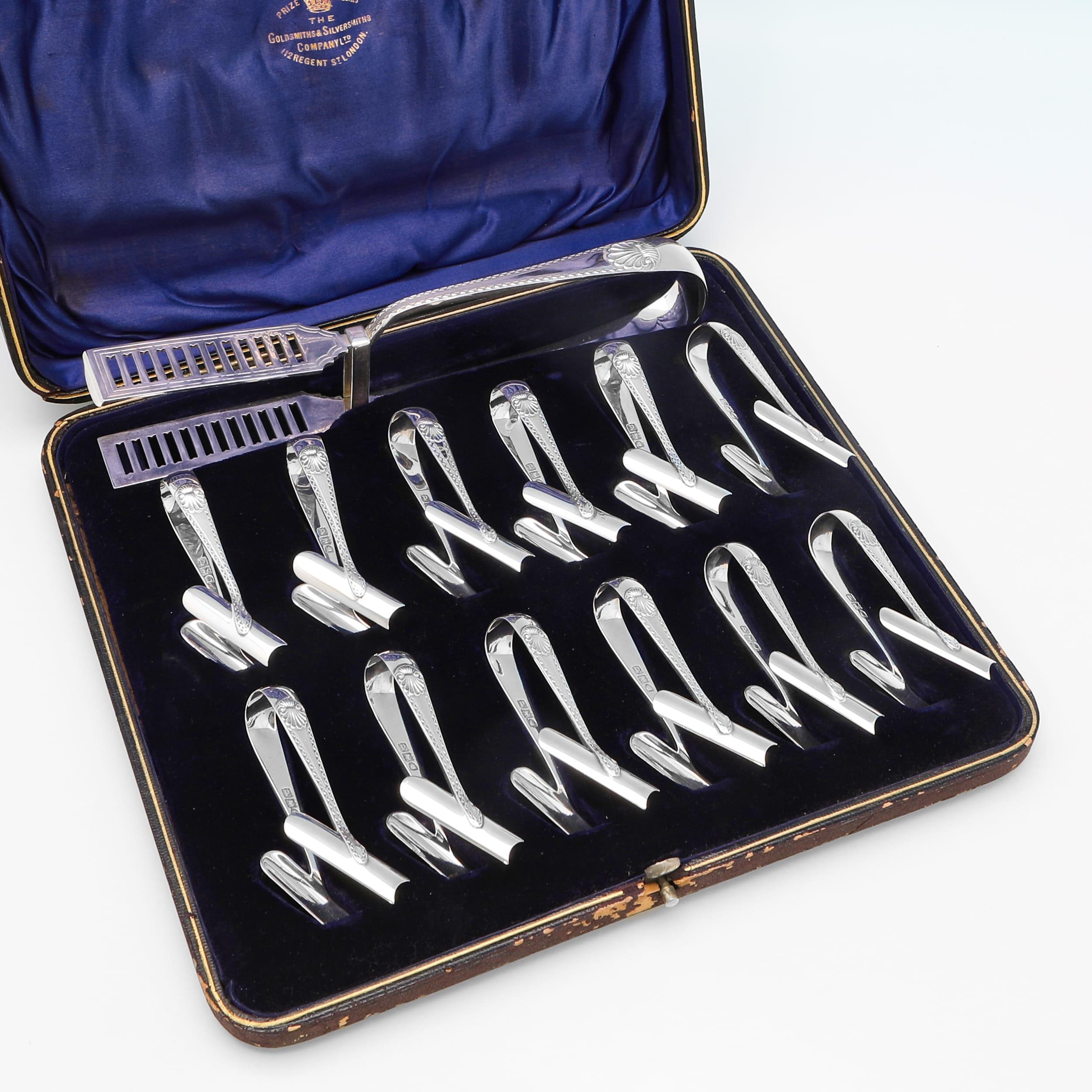 Poinçonné à Londres en 1899 par Goldsmiths & Silversmiths Co., cet élégant service à asperges victorien en argent sterling ancien comprend 12 paires d'asperges et une paire de couverts à asperges, tous ornés de bordures gravées en zigzag et de
