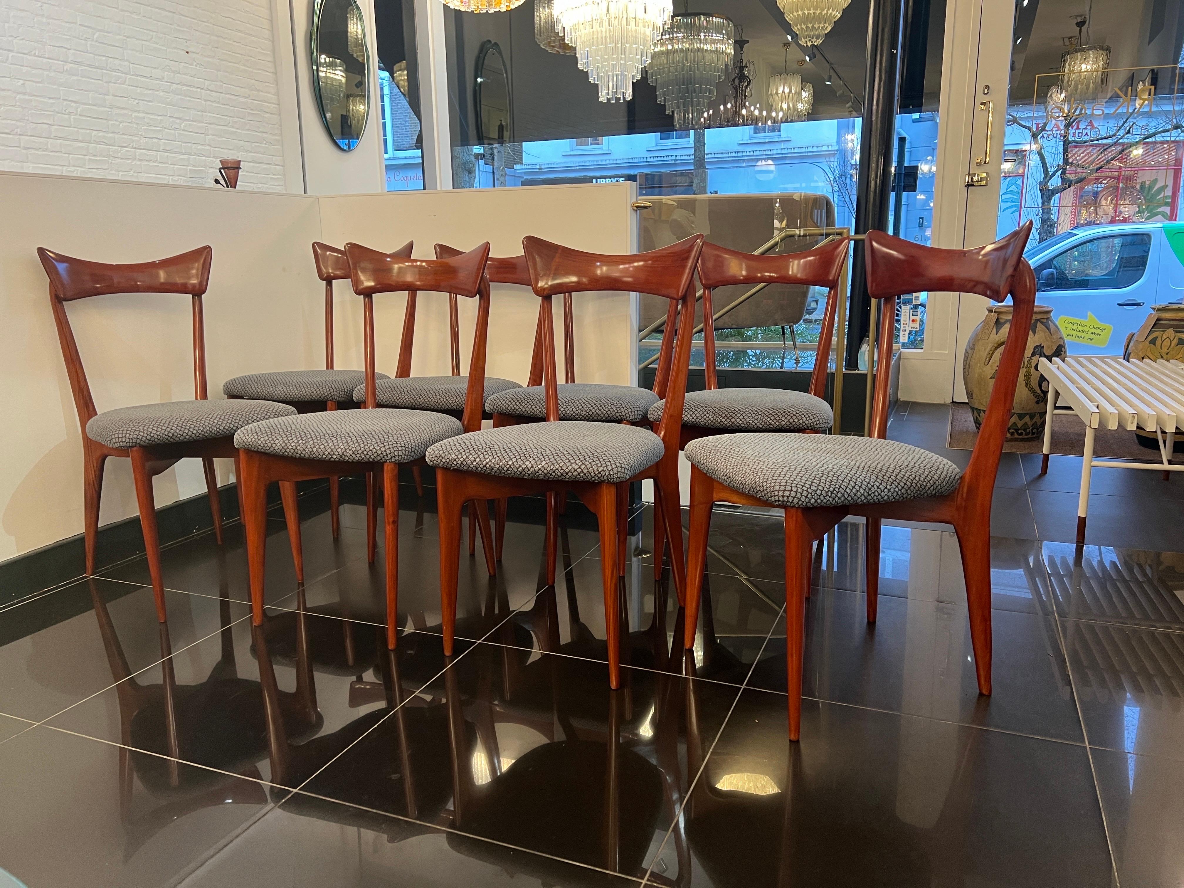 This wonderful set of 8 rare cherrywood dining chairs by Ico & Luisa Parisi for Ariberto Colombo, Cantù . Sculptural  frame with a curved papillon shaped backrest. The seats are newly upholstered in fine blue grey mosaic Jacquard fabric .