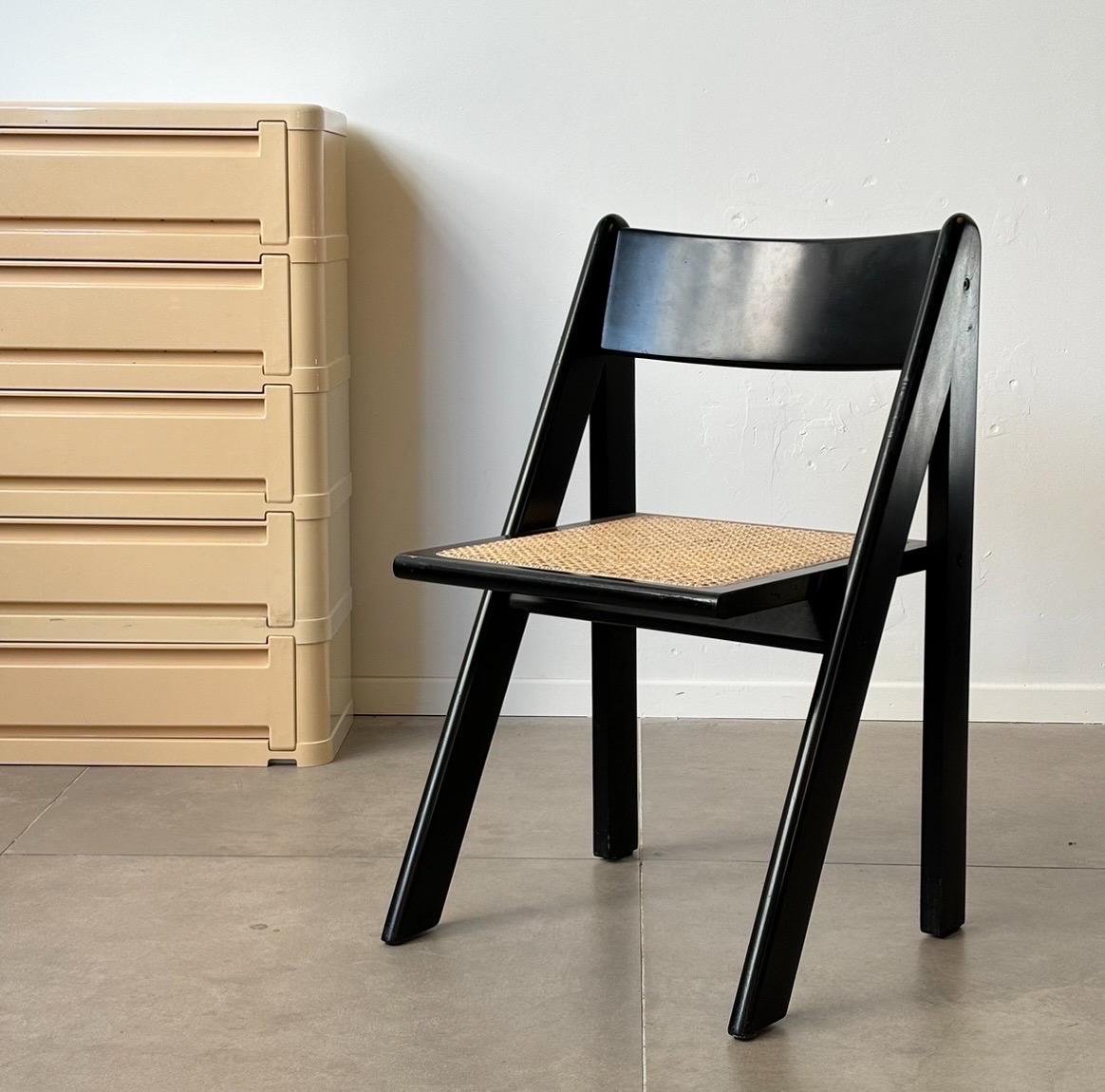 Ce rare ensemble de quatre chaises en bois laqué noir et en rotin, fabriquées en Italie dans les années 1960, illustre le design et l'artisanat exquis du mobilier moderne du milieu du siècle dernier. Les cadres élégants laqués noirs offrent un