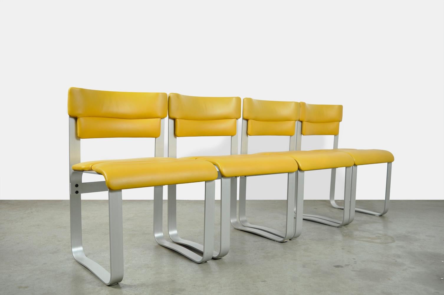 Rare ensemble de 4 chaises de salle à manger attribué au designer finlandais Ilmar Lappalainen et Asko, Finlande des années 1960. Les chaises spéciales ont un cadre incurvé en aluminium anodisé avec une assise et un dossier en similicuir jaune. Les