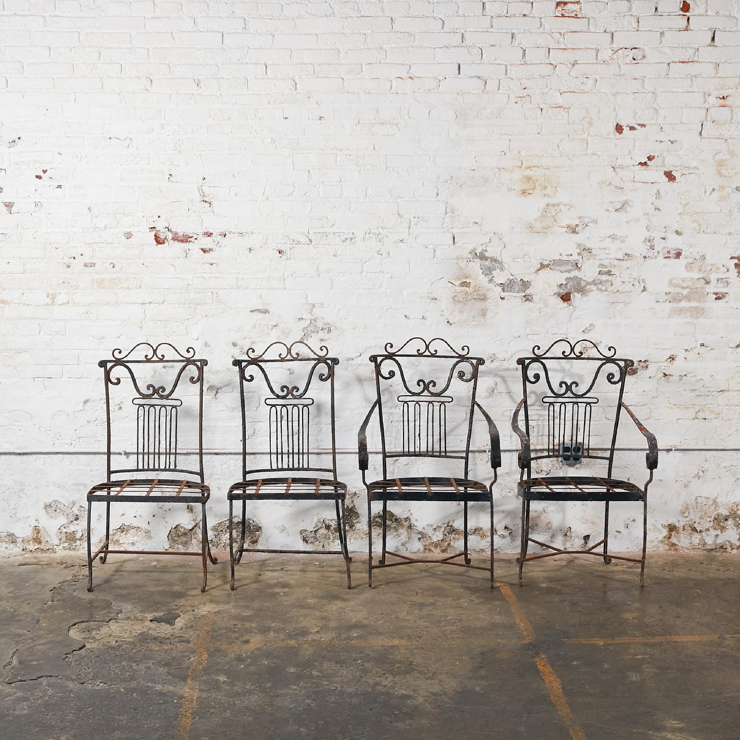 Rare set of four garden or patio chairs with their original patina. Two with arms and two without. The back on four chairs is beautifully embellished with a very stylish design.