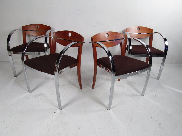This stunning vintage modern set of dining chairs boast curved flat bar chrome armrests and a walnut backrest. An unusual two-tone midcentury design that offers optimal comfort without sacrificing style. The thick padded seat with dark-colored