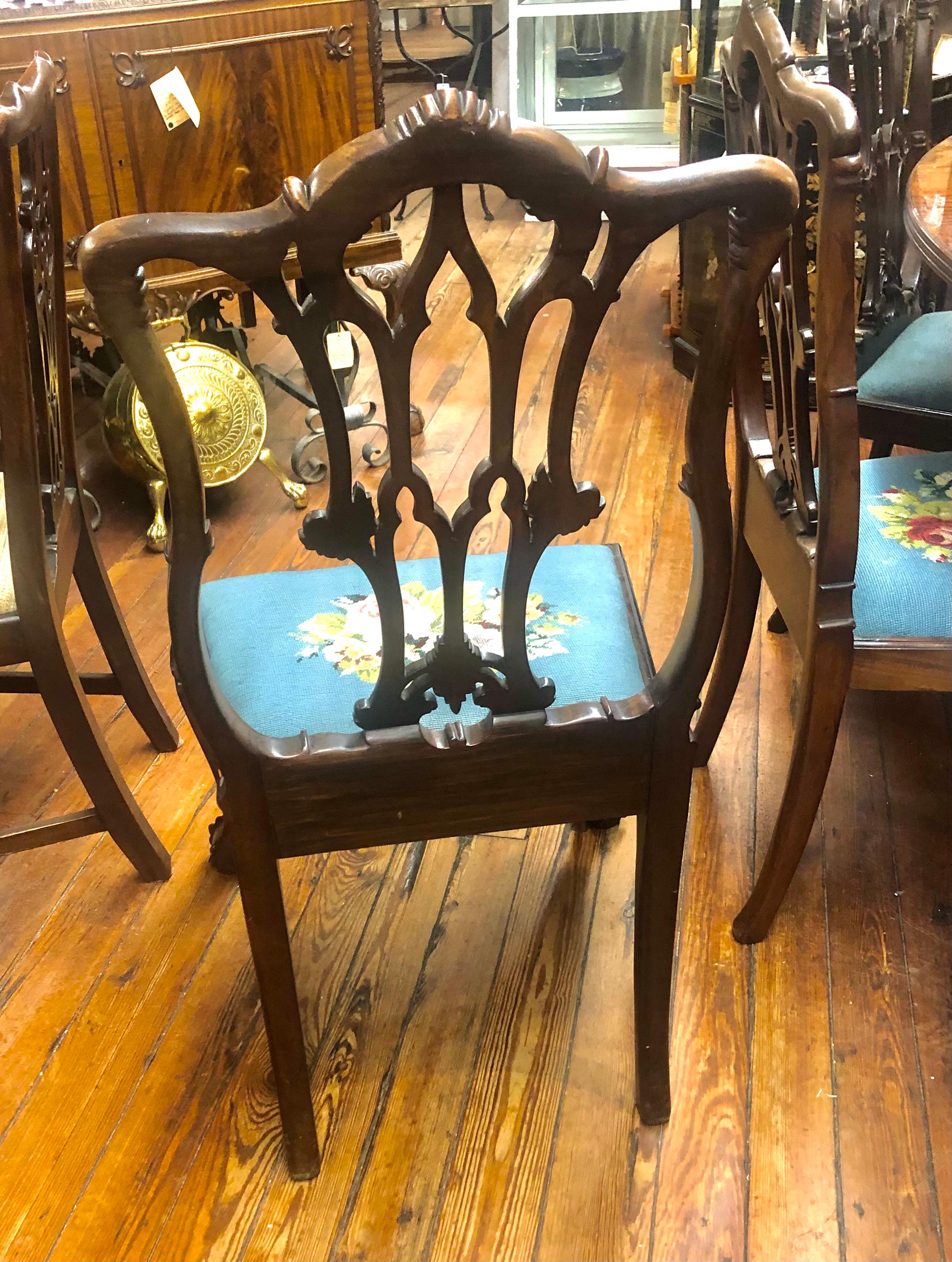 An extraordinarily fine and rare set of ten (all side chairs) antique Irish Chippendale style hand carved and pierced solid mahogany dining chairs with antique needlepoint upholstered seats. These chairs are profusely and finely hand carved and