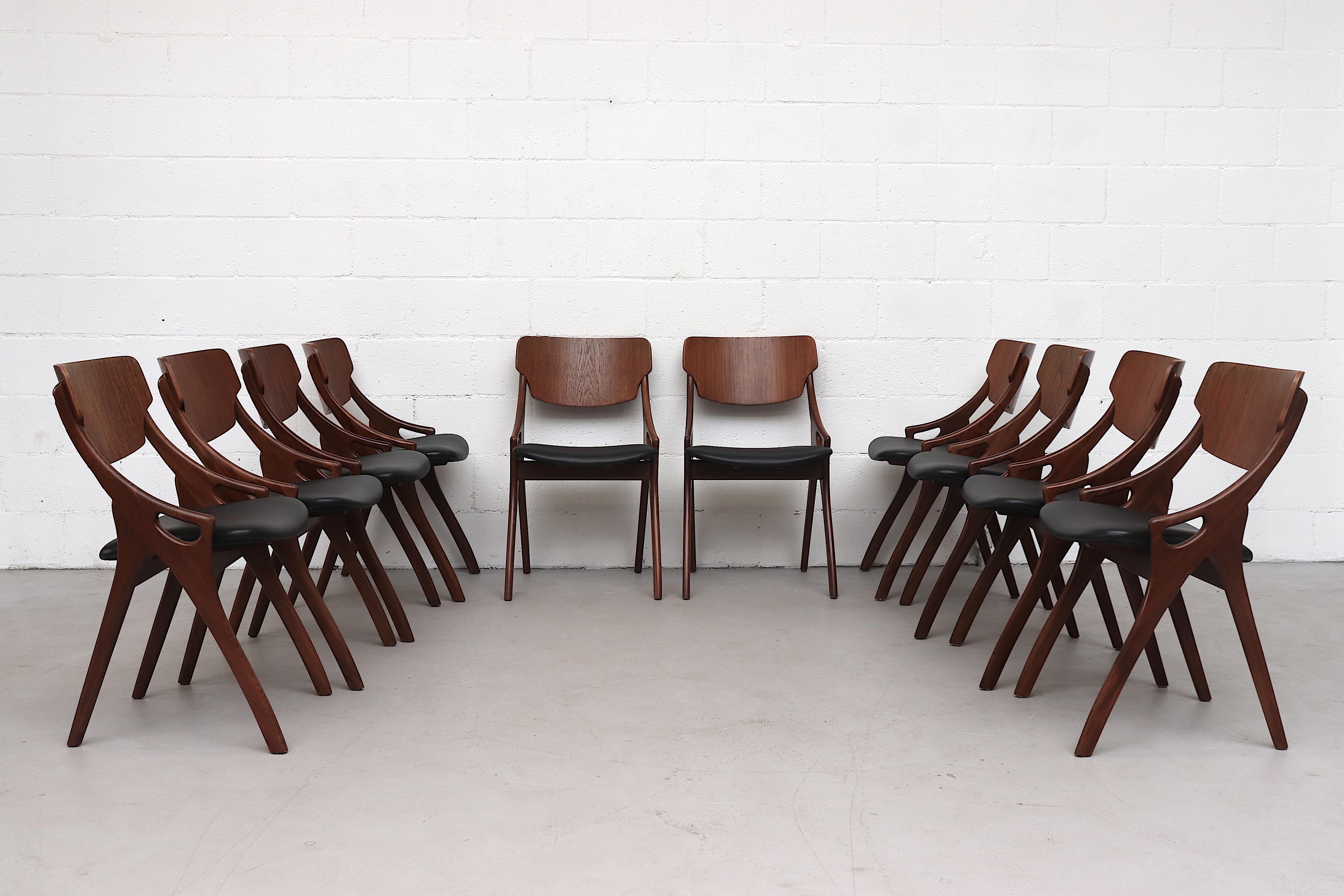 Set of ten teak dining chairs by Arne Hovmand Olsen for Mogens Kold. Manufactured in the 1950s, Denmark. Each chair features organically sculpted teak arms with teak backrests and original black skai seating with visible wear. All the chairs are in