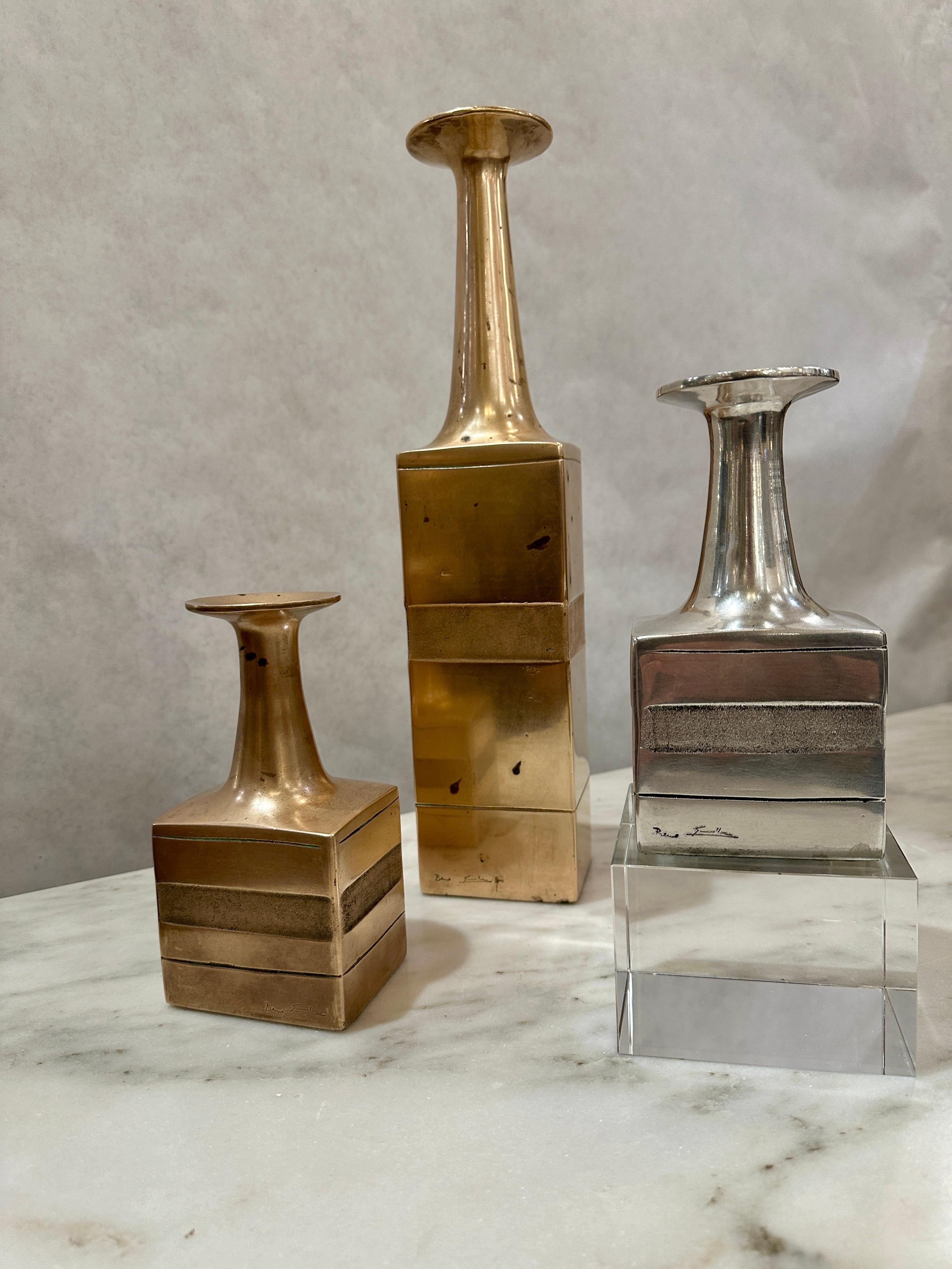 Rare Set of Bruno Gambone artist signed bronze bottle form vases - three of them (two in bronze and one in white bronze, which is VERY RARE).  Bottles with quadrangular section in cast bronze, elongated neck and flared rim.  Typical of Gambone's