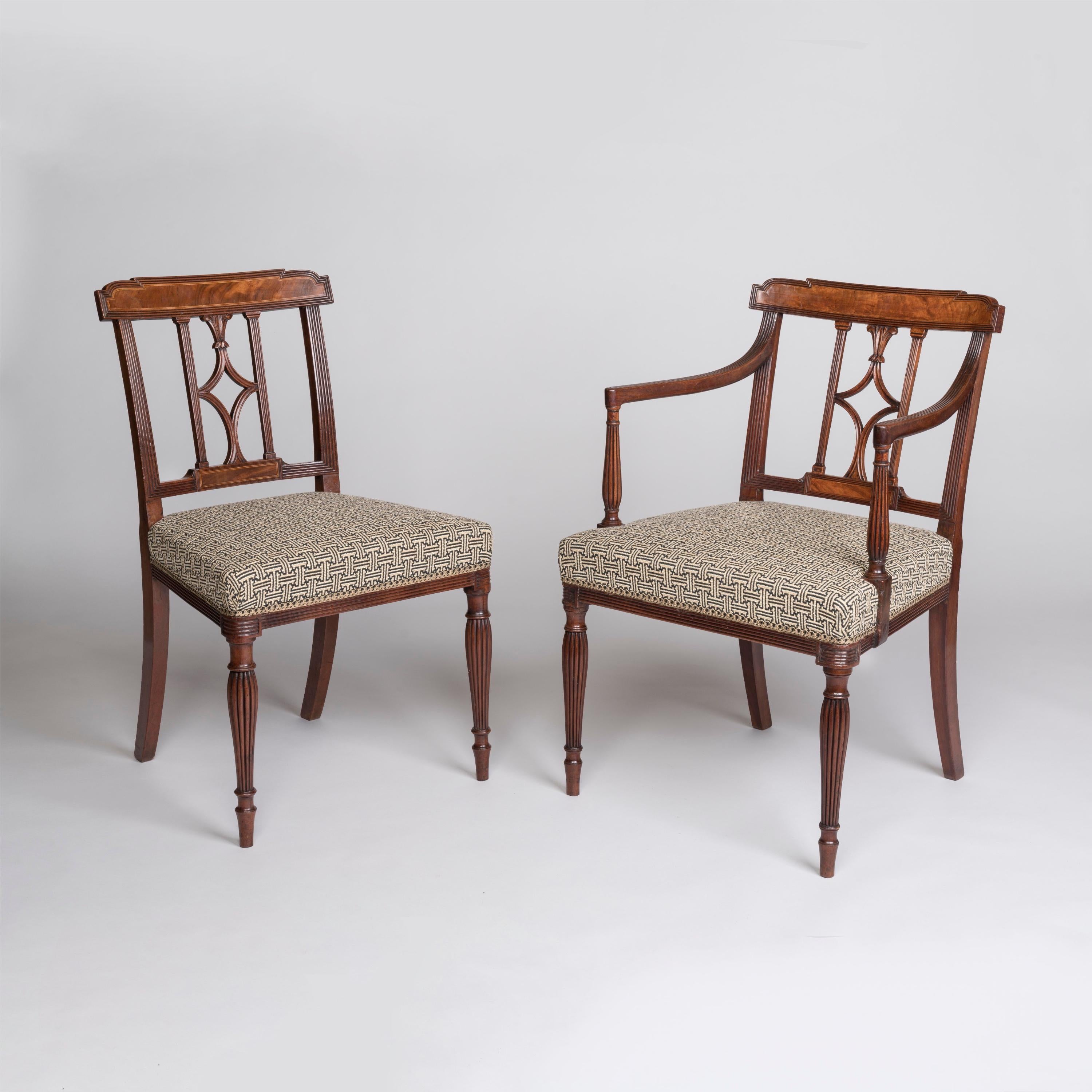 Ein feiner Satz von zwölf Mahagoni-Esszimmerstühlen aus der Zeit von Georg III.
Nach dem Vorbild von Thomas Sheraton

Das Set besteht aus einem Paar Sesseln mit offenen Armlehnen auf balusterförmigen, gerippten Stützen, die gepolsterte Sitze