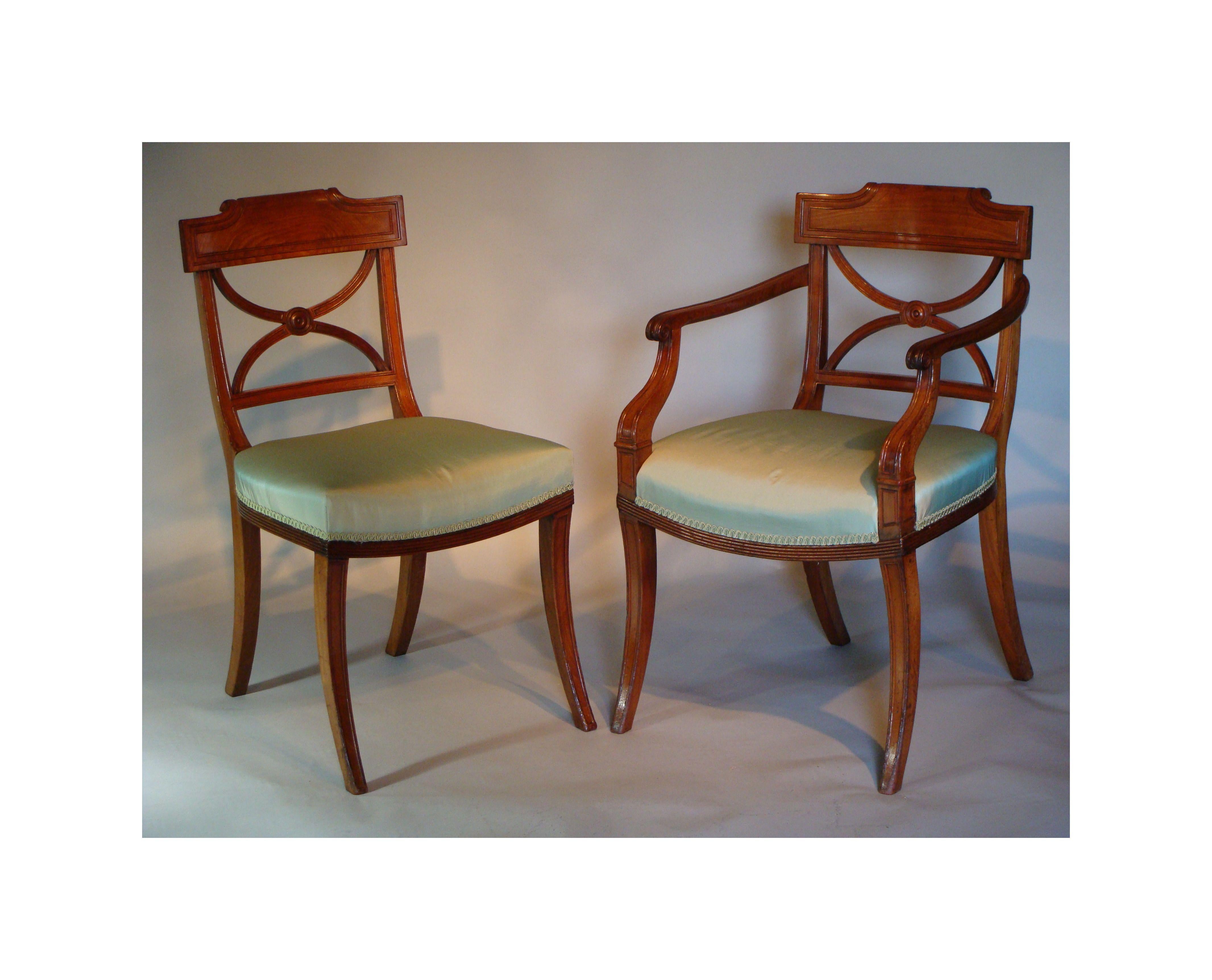 An impressive and rare set of twenty (18 + 2) antique (George lll period) mahogany dining chairs, including a pair of open armchairs. 
Ca 1810.

Of excellent quality, colour and condition.

The carved and moulded frames raised on sabre legs. The