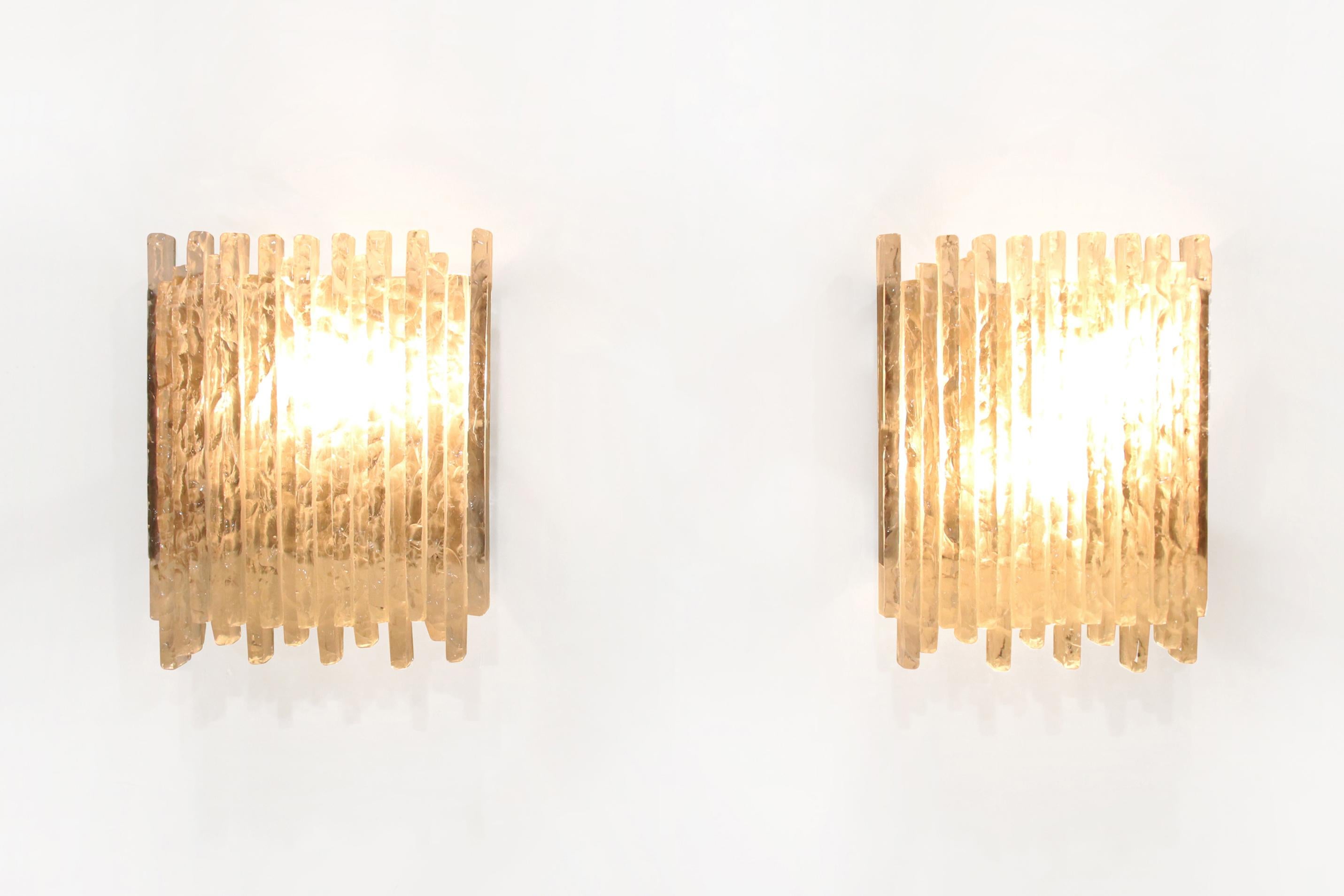Raro juego de dos apliques Poliarte Vesta de Albano Poli. Estas preciosas lámparas Brutalistas están fabricadas con varillas de vidrio martillado hechas a mano, lo que permite que el motivo irregular cree encantadores patrones de luces y sombras. La
