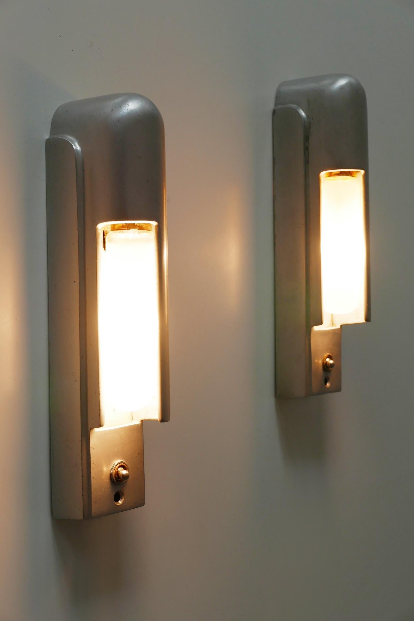 Set di due eccezionali ed eleganti applique o lampade da parete dal design lineare. Queste due straordinarie applique avrebbero dovuto trovarsi su una nave da crociera americana. Prodotto da The Simes Co. NY, USA, 1930.

Realizzata in fusione di