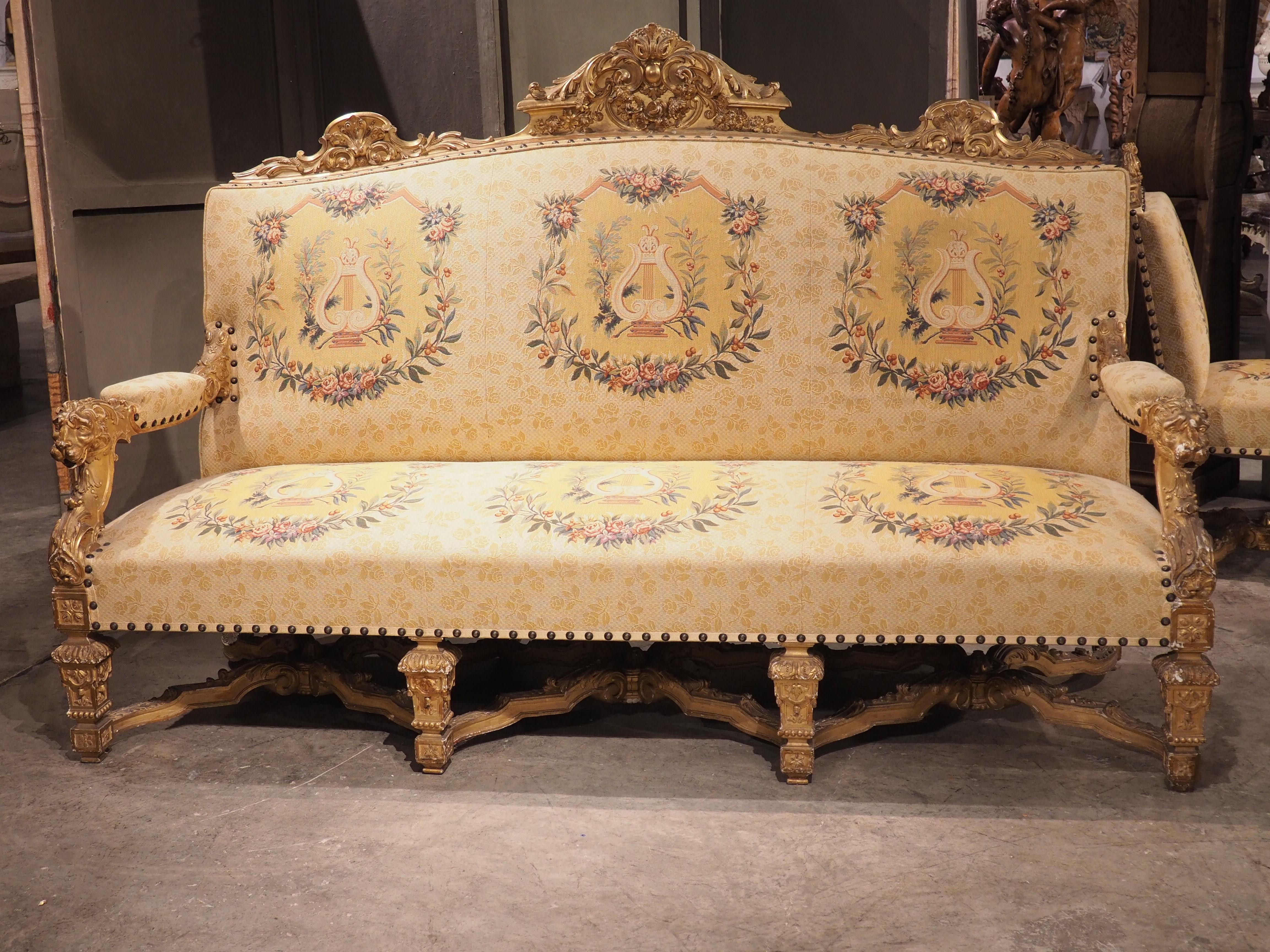 Diese majestätische Chateau-Salon-Suite aus vergoldetem Holz stammt aus Frankreich und ist um 1880 entstanden. Es gibt vier Beistellstühle, zwei Sessel (fauteuils) und ein Kanapee. Alle haben quadratische Balusterbeine und volutenförmige X-Strecker.